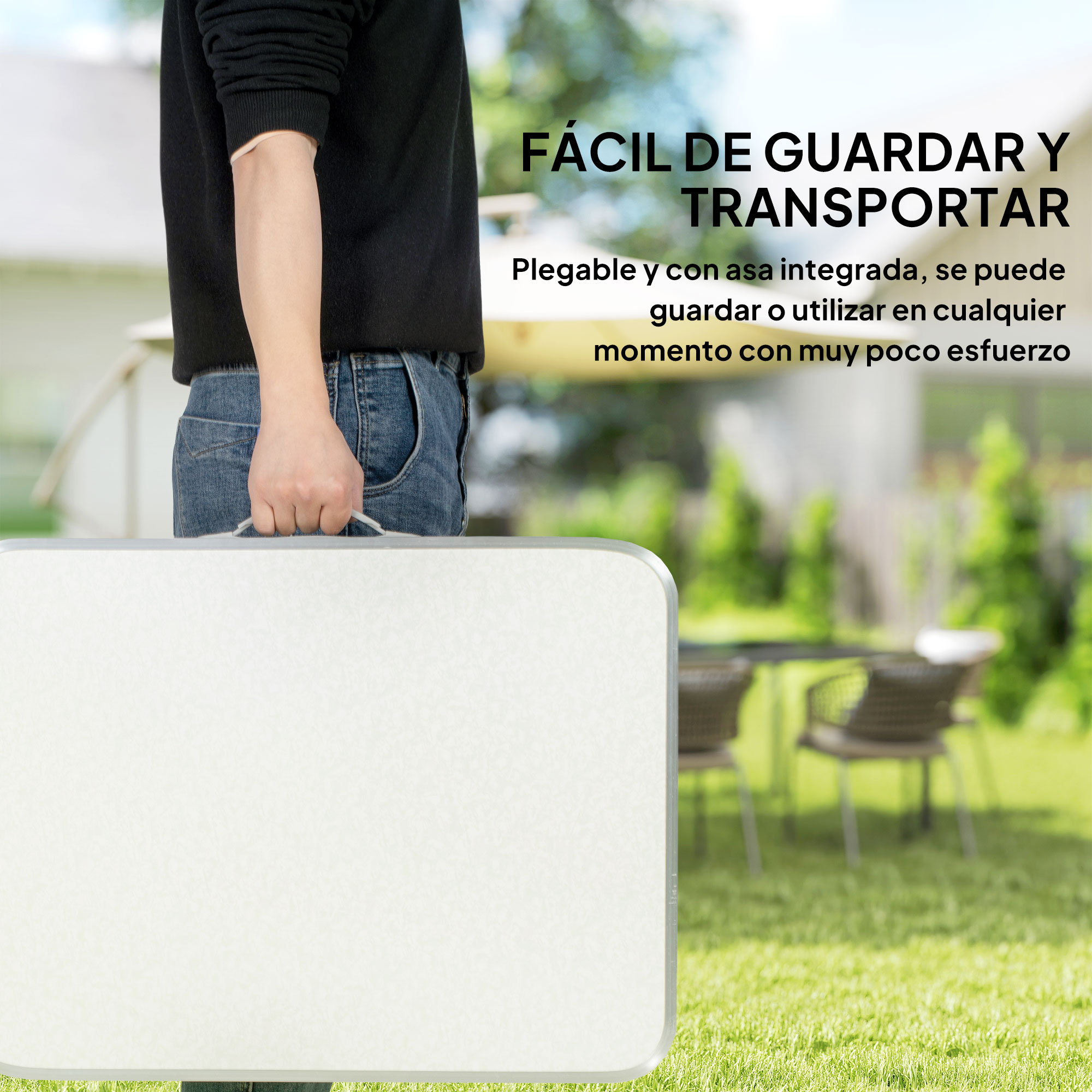 Una superficie de mesa blanca y portátil con asa se sujeta al aire libre en el césped.