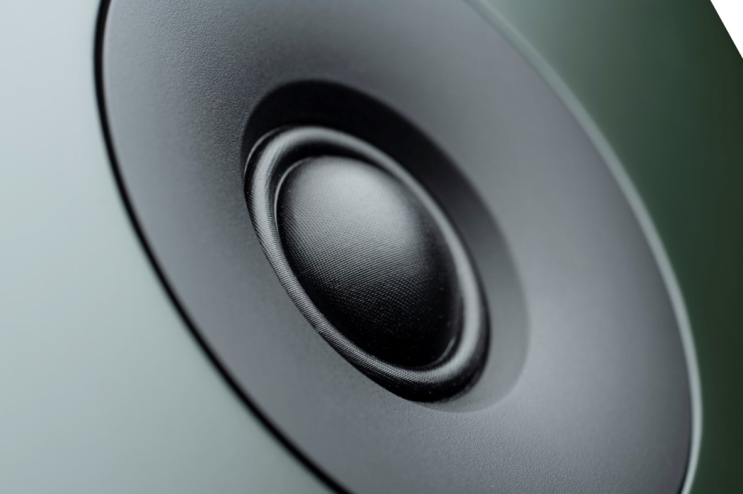 Zbliżenie czarnego głośnika z teksturowanym stożkiem i gumowym zawieszeniem.