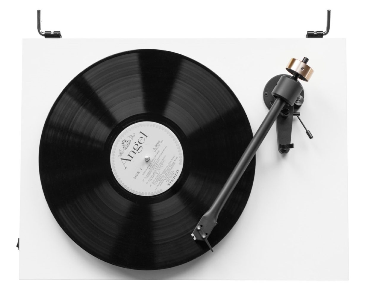 Czarna płyta winylowa obraca się na białym gramofonie, ramię jest gotowe.