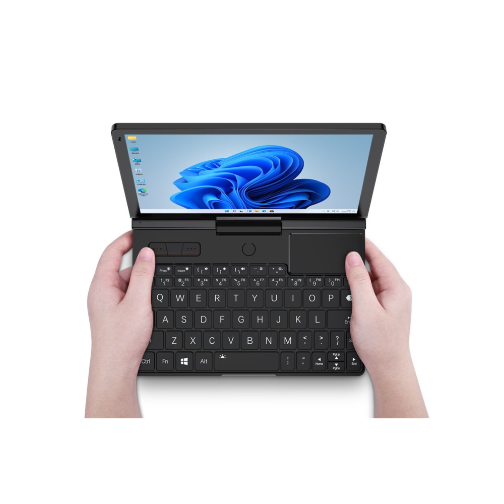 Dłonie trzymają czarny mini laptop z otwartym ekranem, wyświetlającym system Windows.