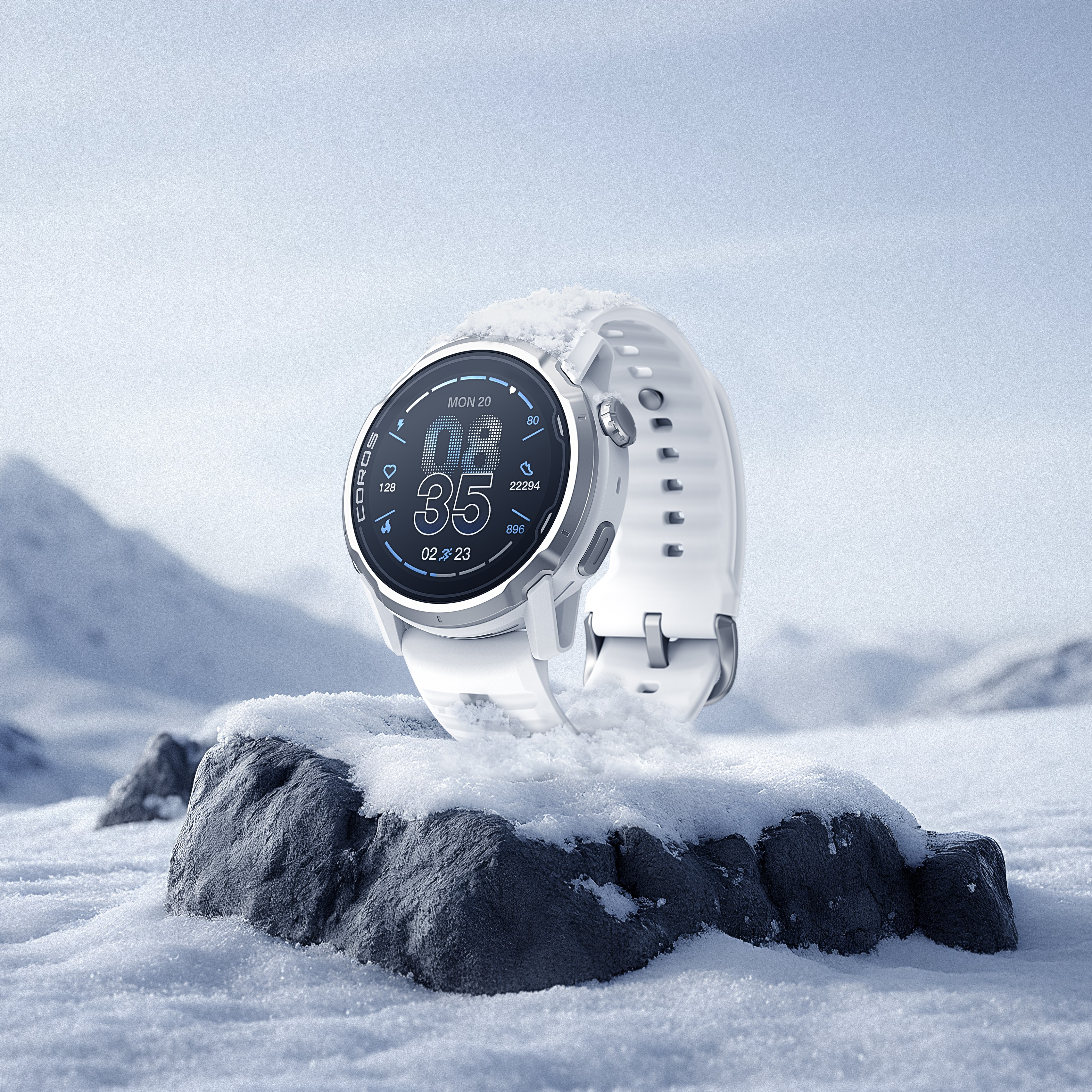 Uno smartwatch bianco con display innevato poggia su una roccia innevata.