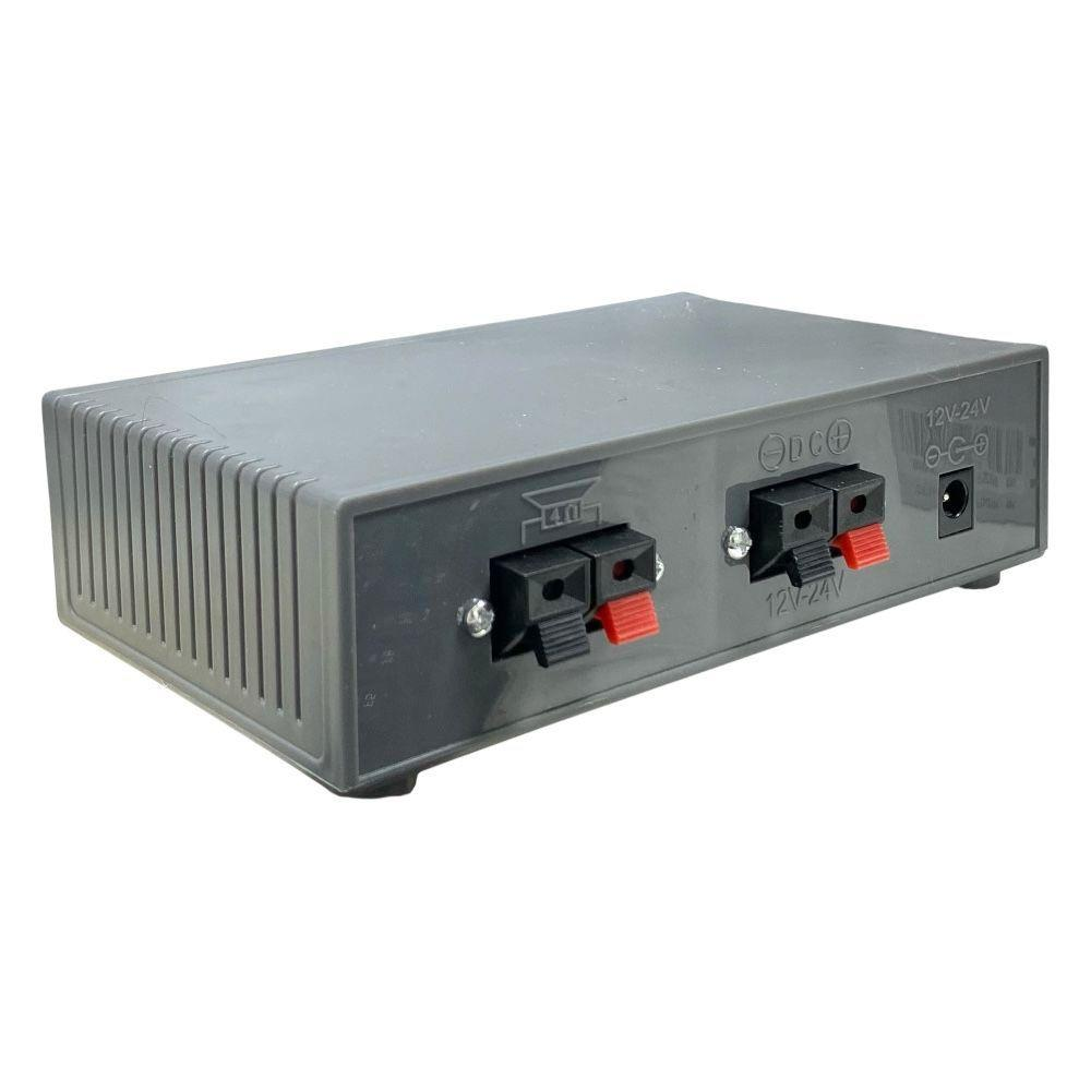 Hoparlör terminalleri ve DC girişi olan gri elektronik cihaz. 12V-24V işareti.