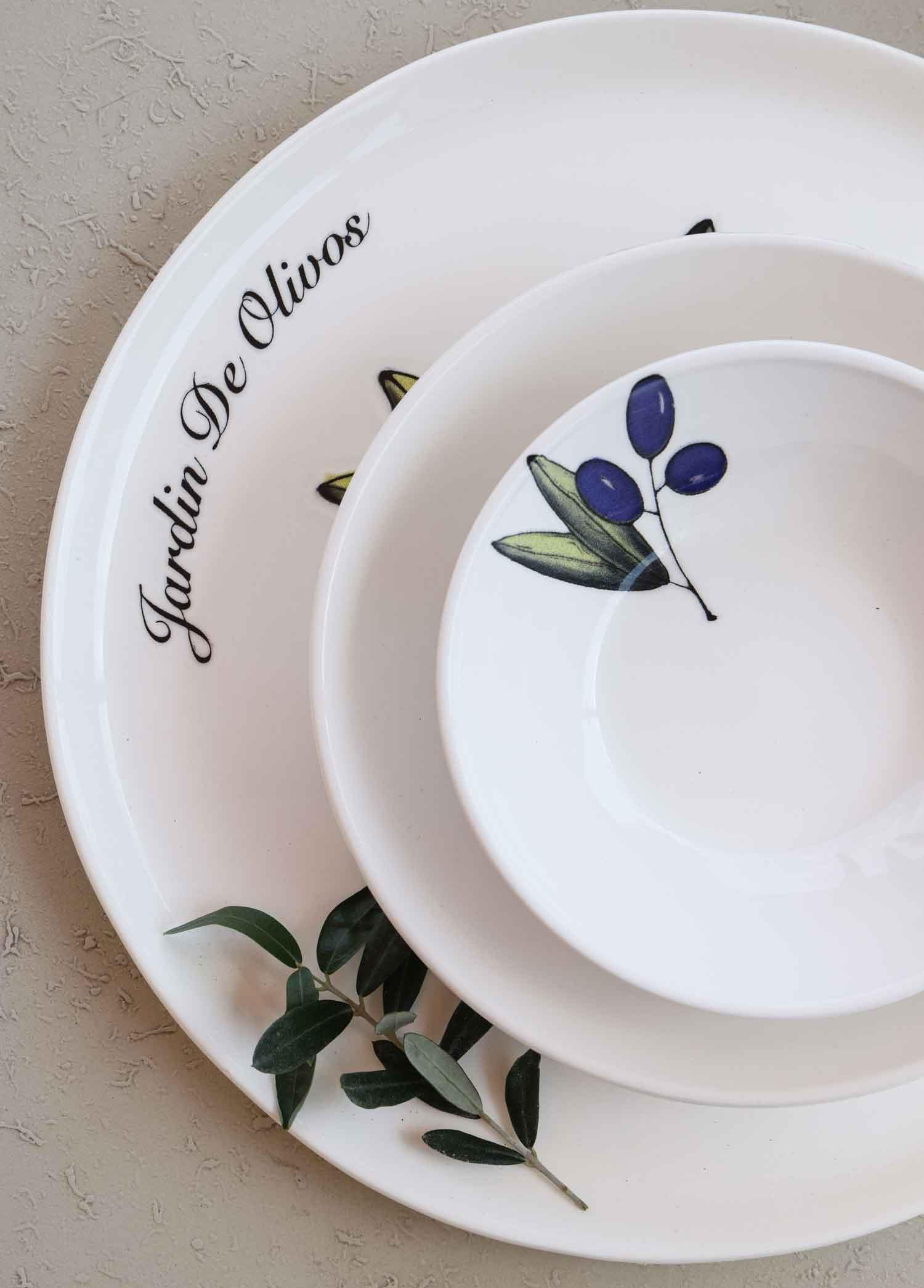 Zeytin dalı süslemeli ve "Jardin De Olivos" yazılı beyaz tabaklar.
