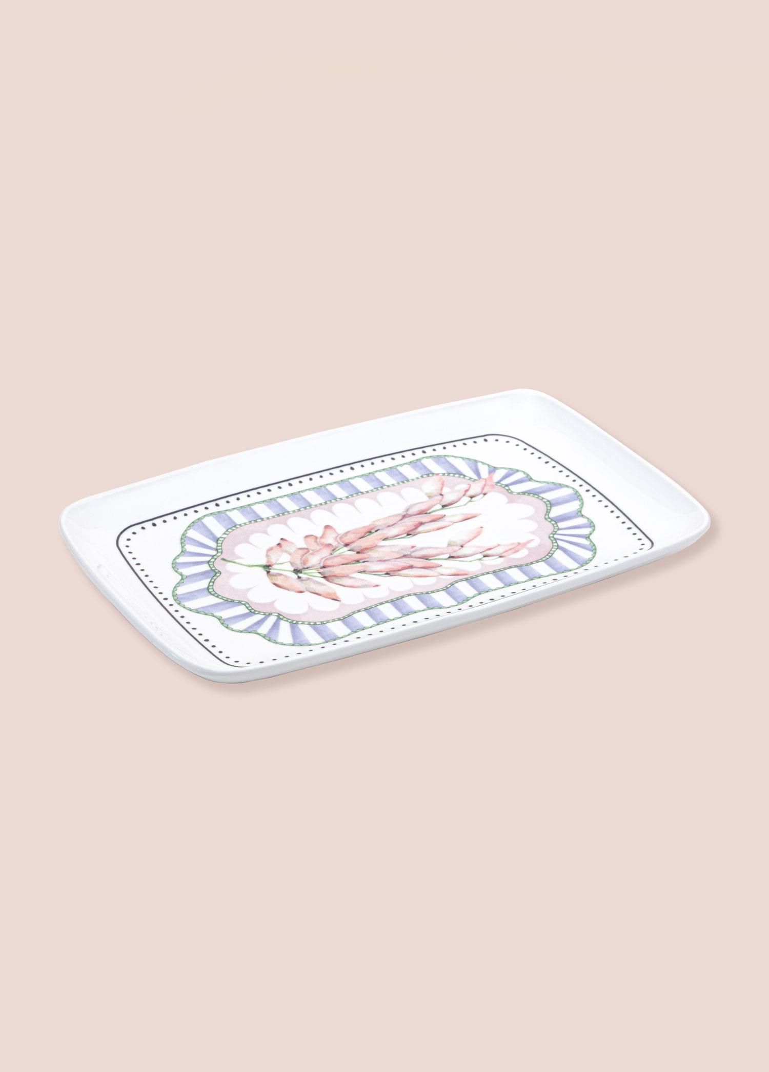 Açık pembe arka plan üzerinde pembe mercan desenli beyaz dikdörtgen tabak.