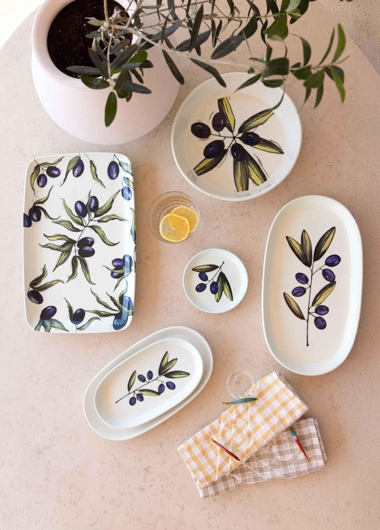 Zeytin dalı desenli seramik tabaklar, yanında limon dilimli küçük bir tabak.