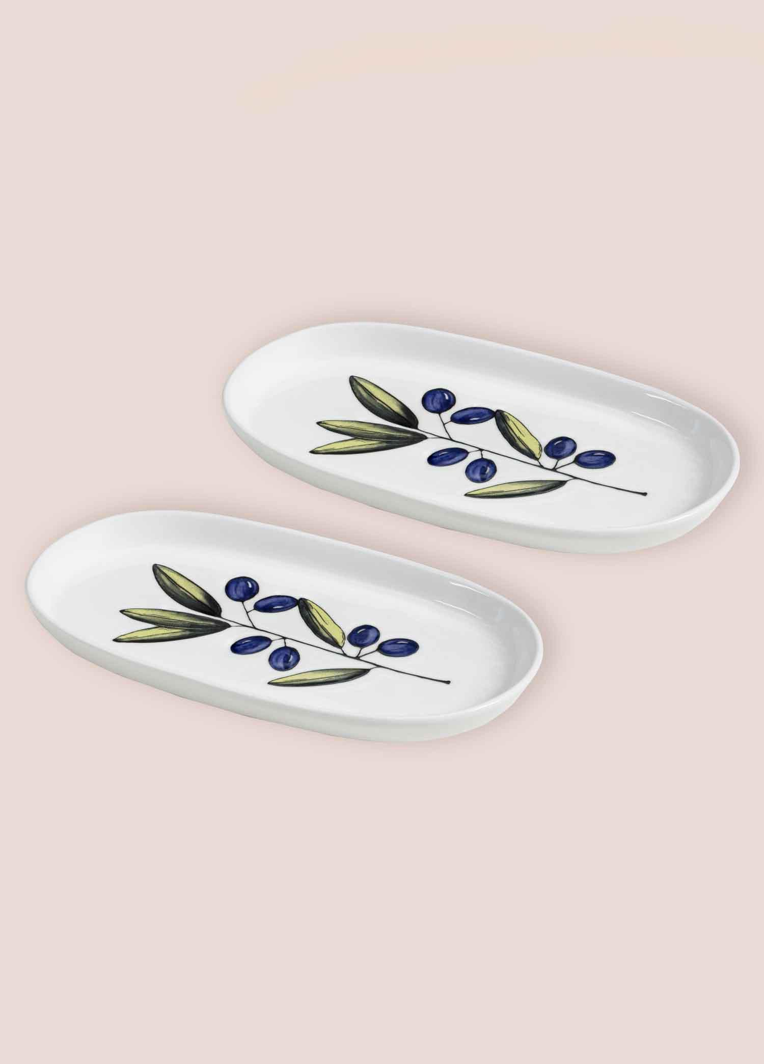 Mavi zeytin dalı desenli iki beyaz oval tabak.