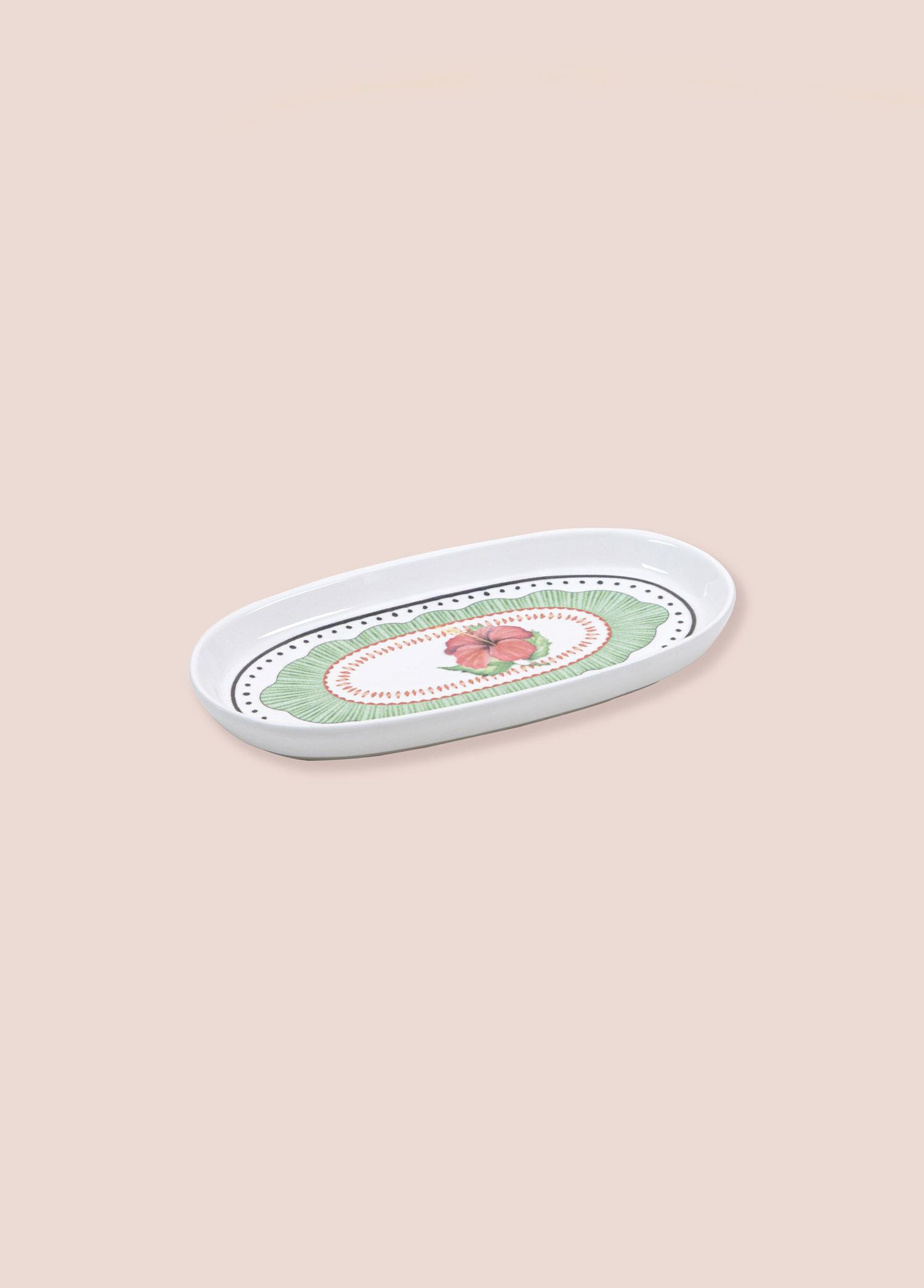 Yeşil fırfırlı kenarlı ve pembe çiçekli tasarımlı beyaz oval tabak.