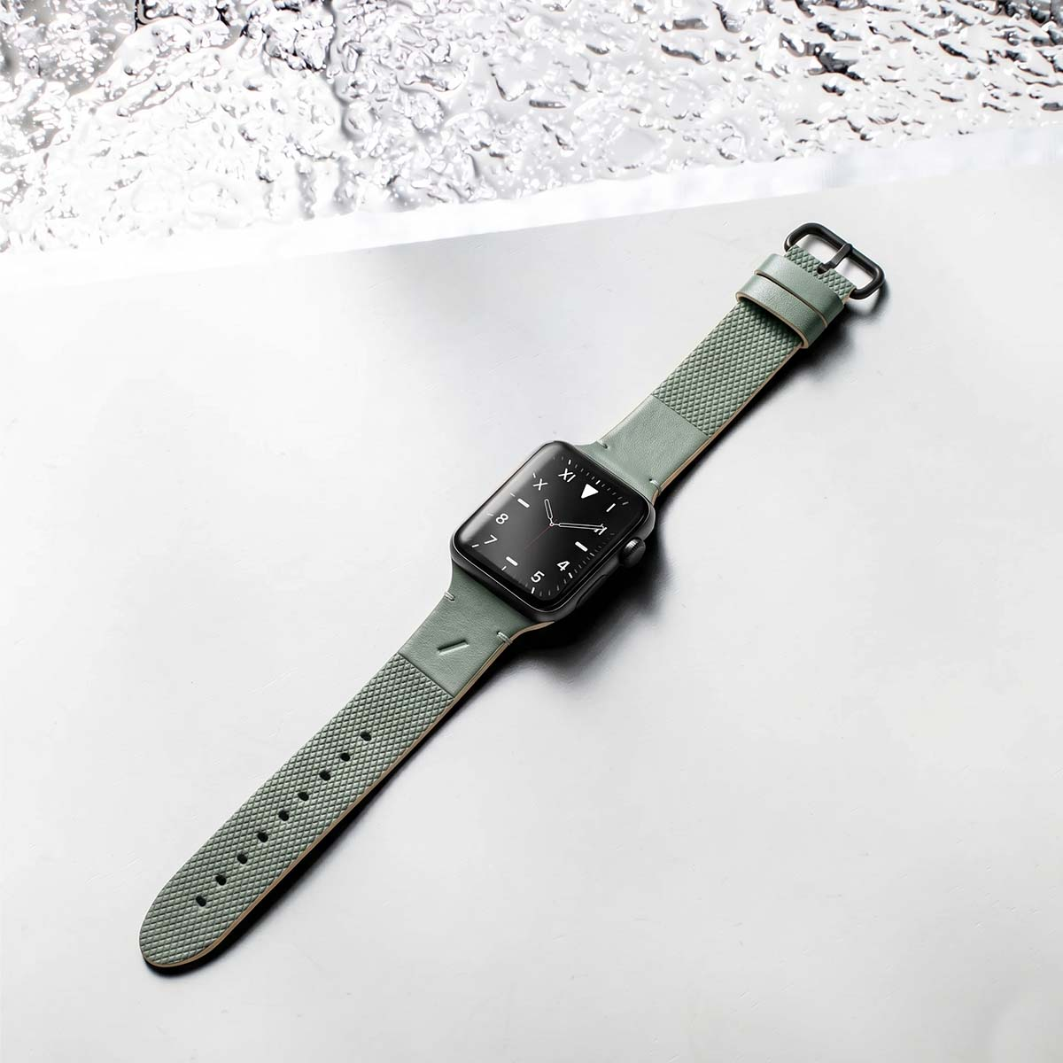 Zielony smartwatch z czarną tarczą spoczywa na gładkiej powierzchni.