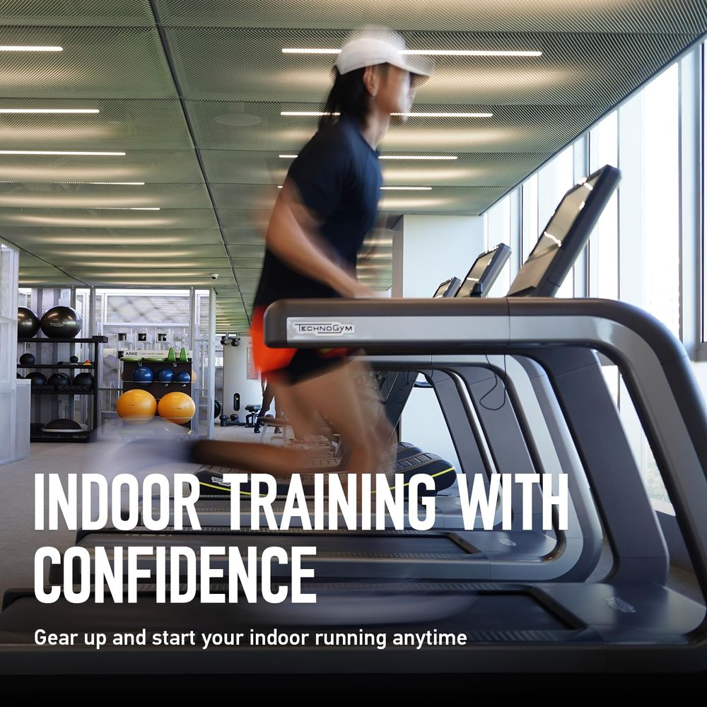 Una persona corre su un tapis roulant in una palestra con ampie finestre.