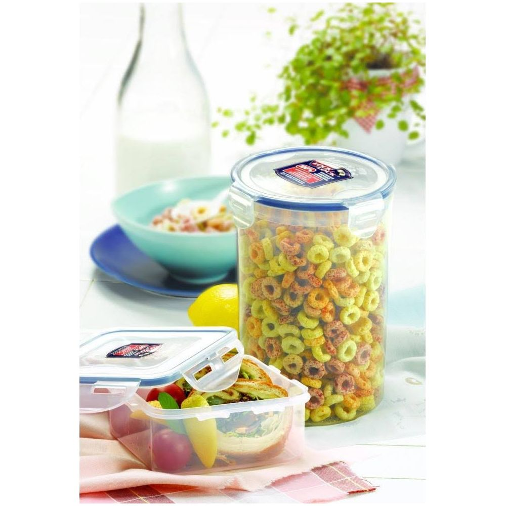 Ein Glas mit bunten Cornflakes, eine Schüssel Müsli, ein Zitronenstück und zwei Behälter mit Essen.