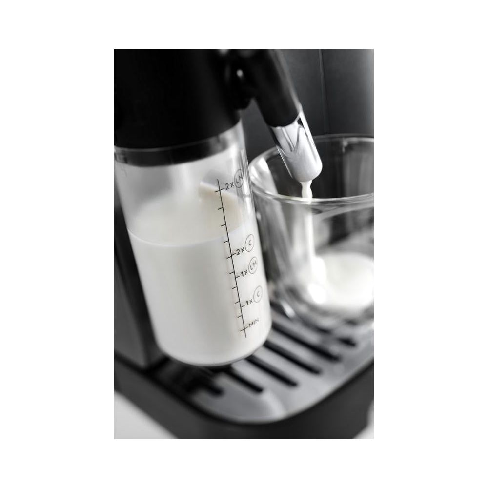 Il latte viene versato da un contenitore in un bicchiere su una macchina da caffè.