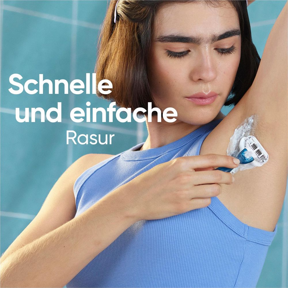 Donna si rade l'ascella con schiuma da barba bianca e un rasoio blu.
