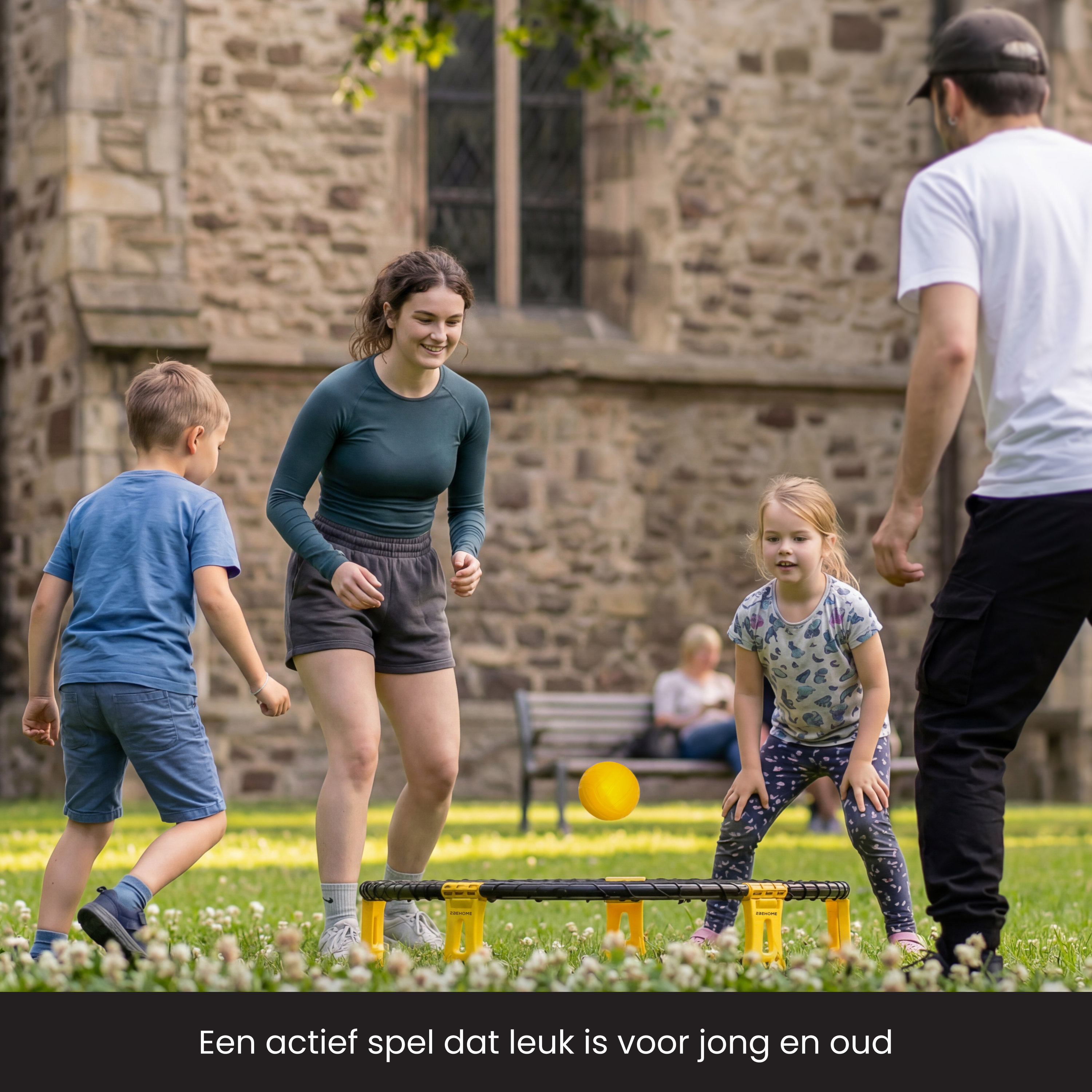Familie spielt draußen ein Spiel mit einem gelben Ball und einem Hakenbrett.