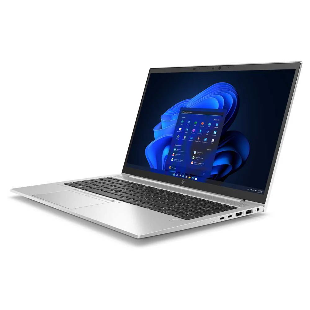 Un portátil plateado con un fondo azul de Windows 11 en la pantalla.