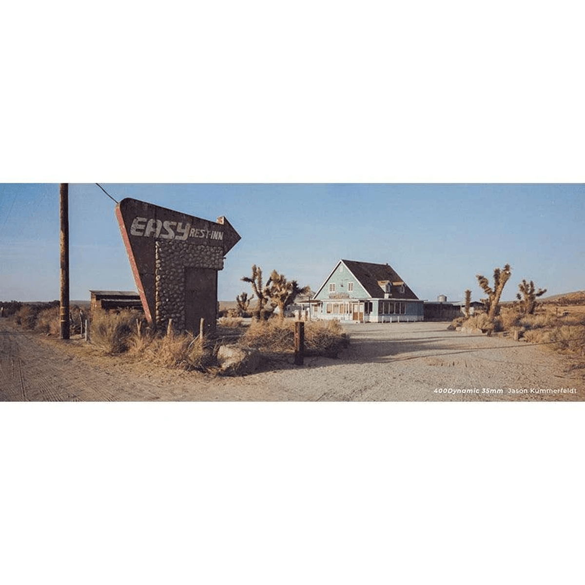 Una escena desértica con un letrero "Easy Rest Inn" y árboles de Josué.