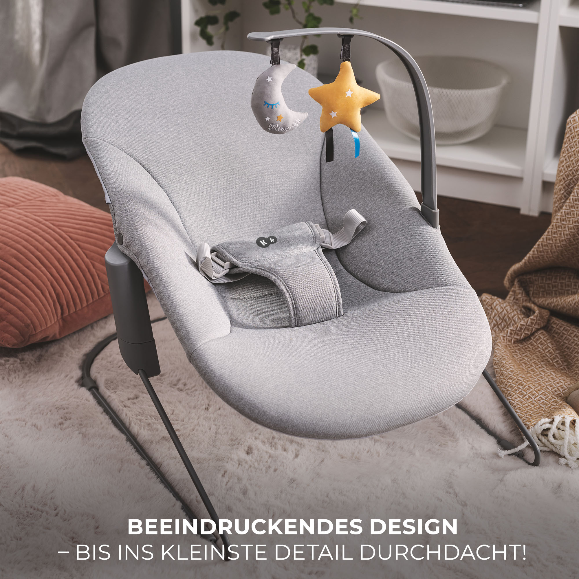 Grauer Babyschaukel mit Spielzeuganhänger (Stern, Mond), auf flauschigem Teppich.