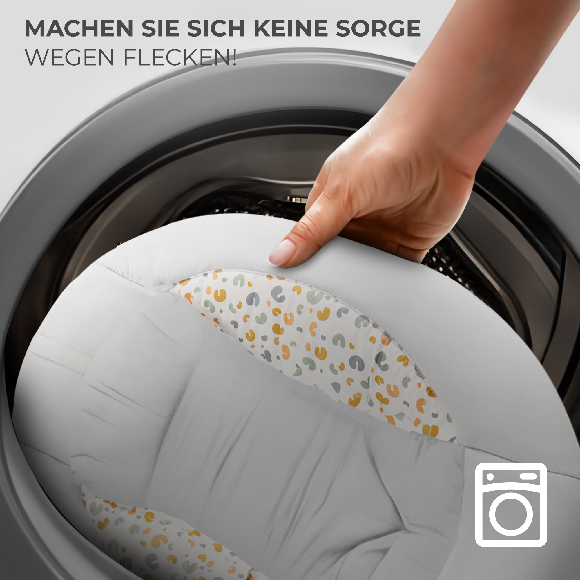 Hand legt weißen Stoff mit Mustern in Waschmaschine.