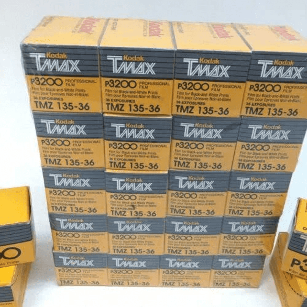Muchas cajas de película Kodak T-MAX P3200 amarillas, apiladas en filas y columnas.