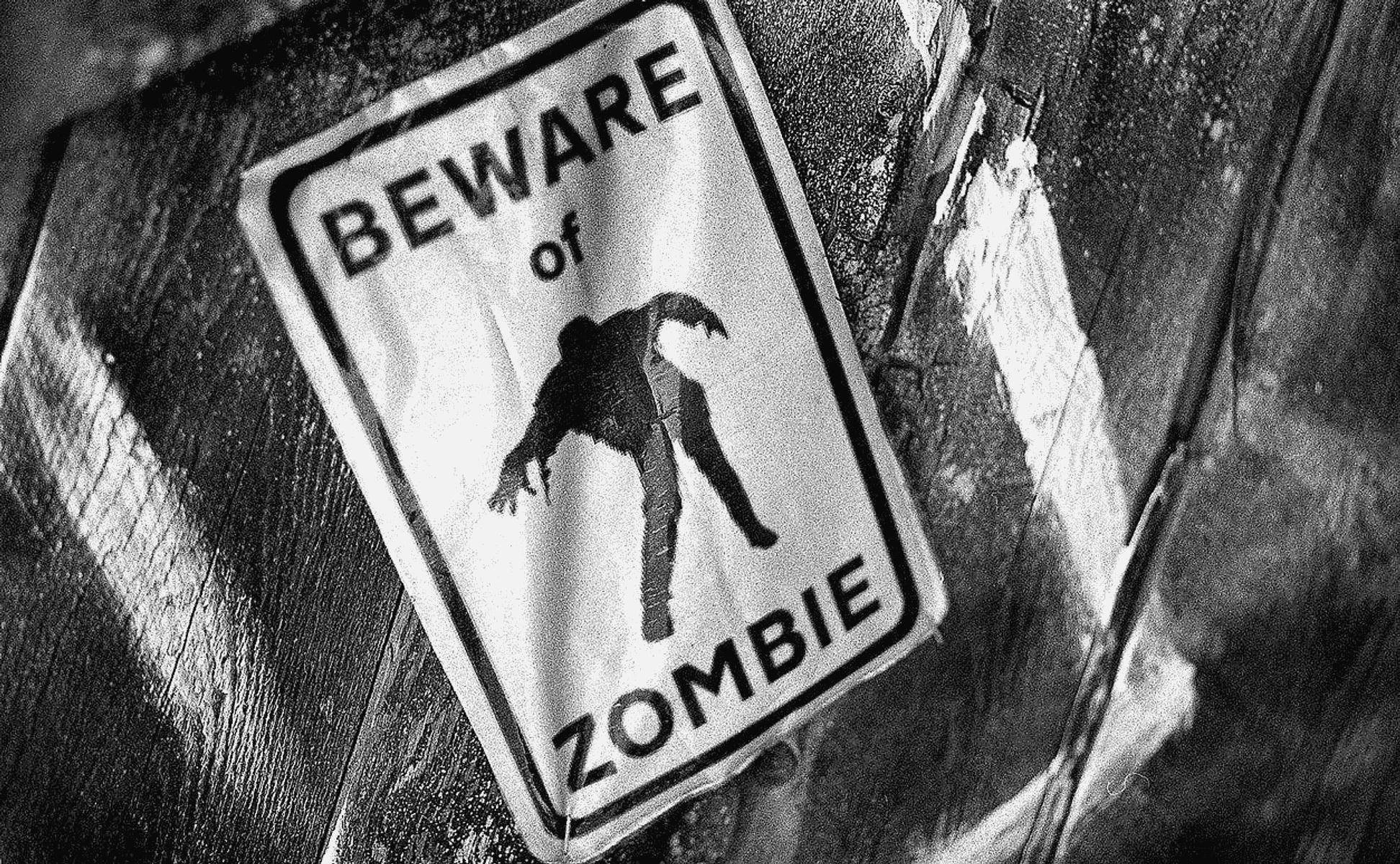 Señal de advertencia con silueta de zombi y texto 'BEWARE of ZOMBIE'.