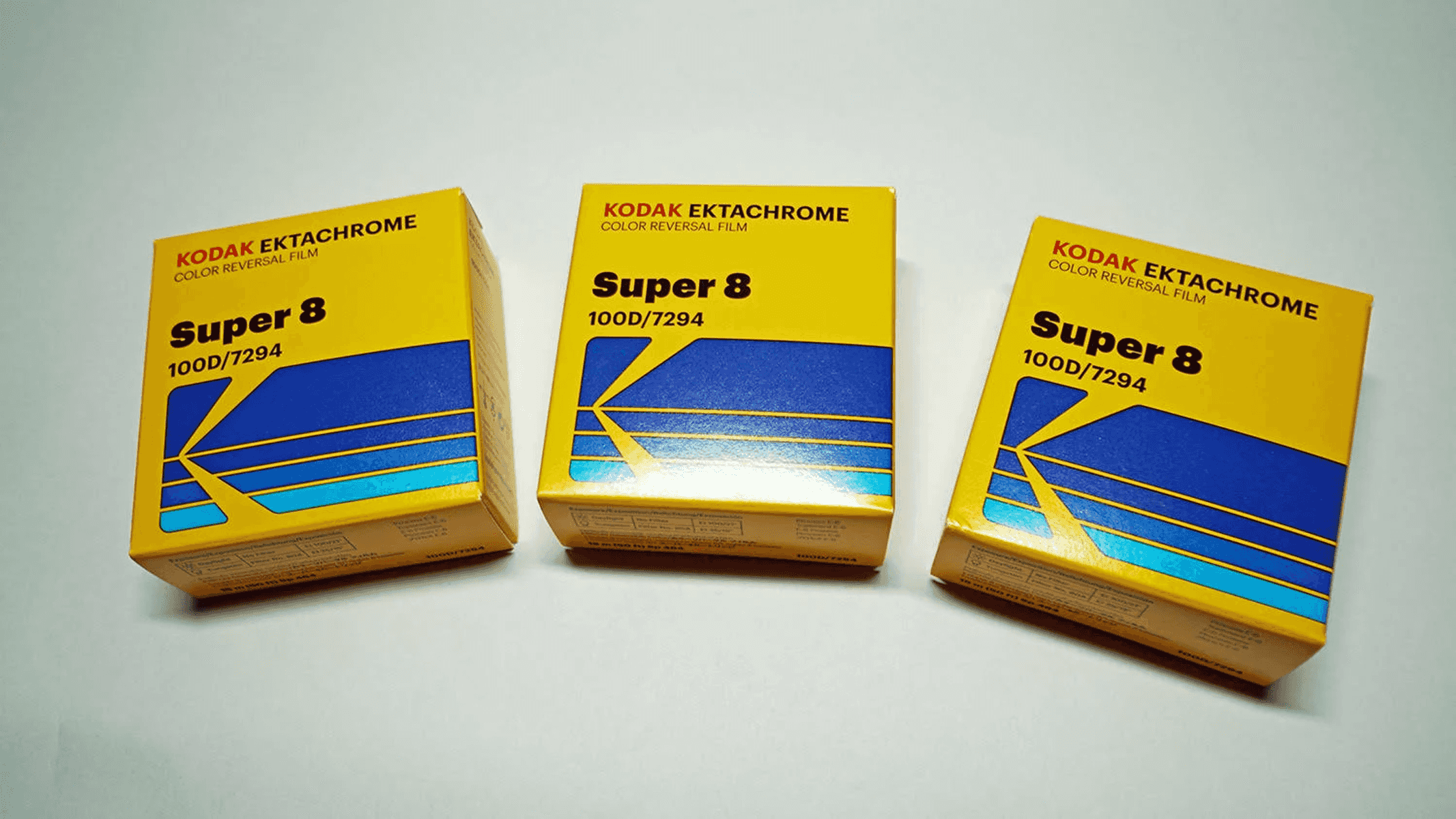 Tres cajas de película Kodak Ektachrome Super 8 amarillas con diseños azul y celeste.