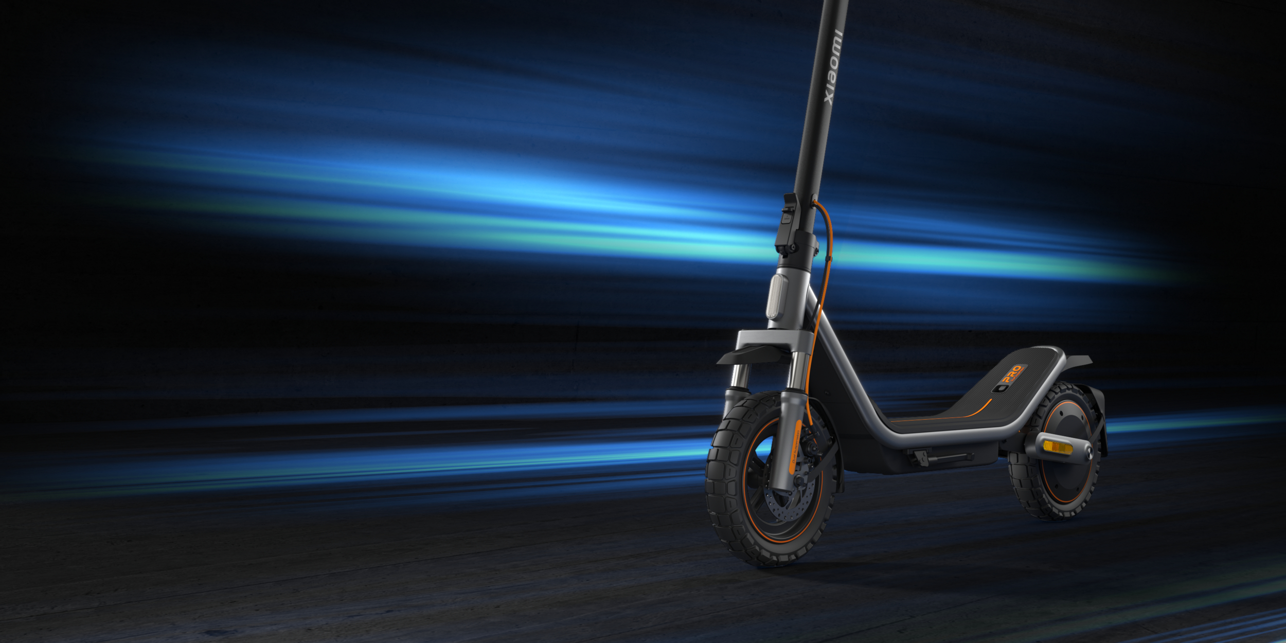 Ein grauer Elektroroller mit orangen Akzenten steht auf einem Holzboden.