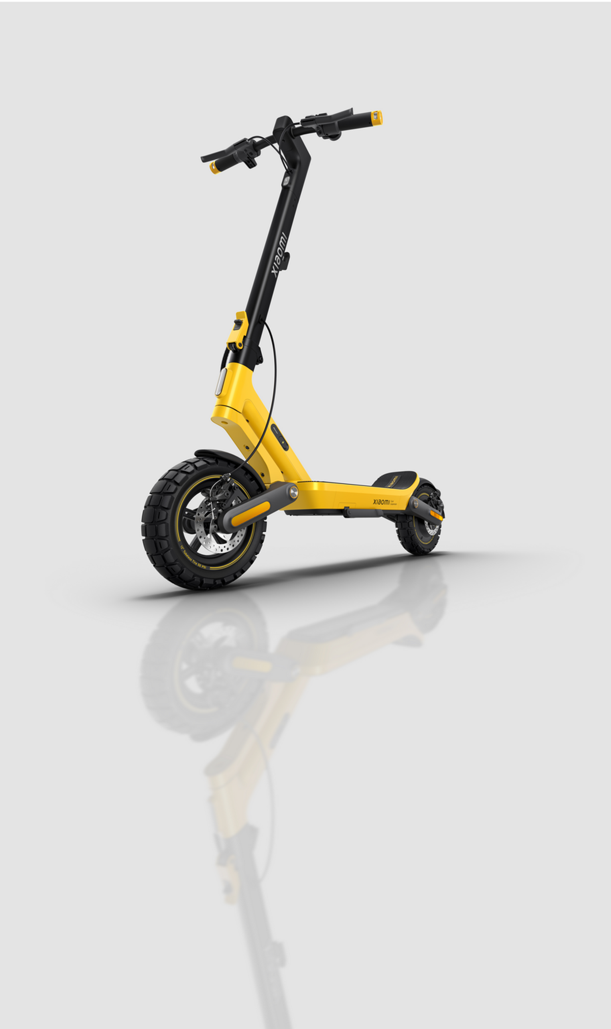 Ein gelber und schwarzer Xiaomi E-Scooter mit großen Rädern steht auf einem hellgrauen Hintergrund.