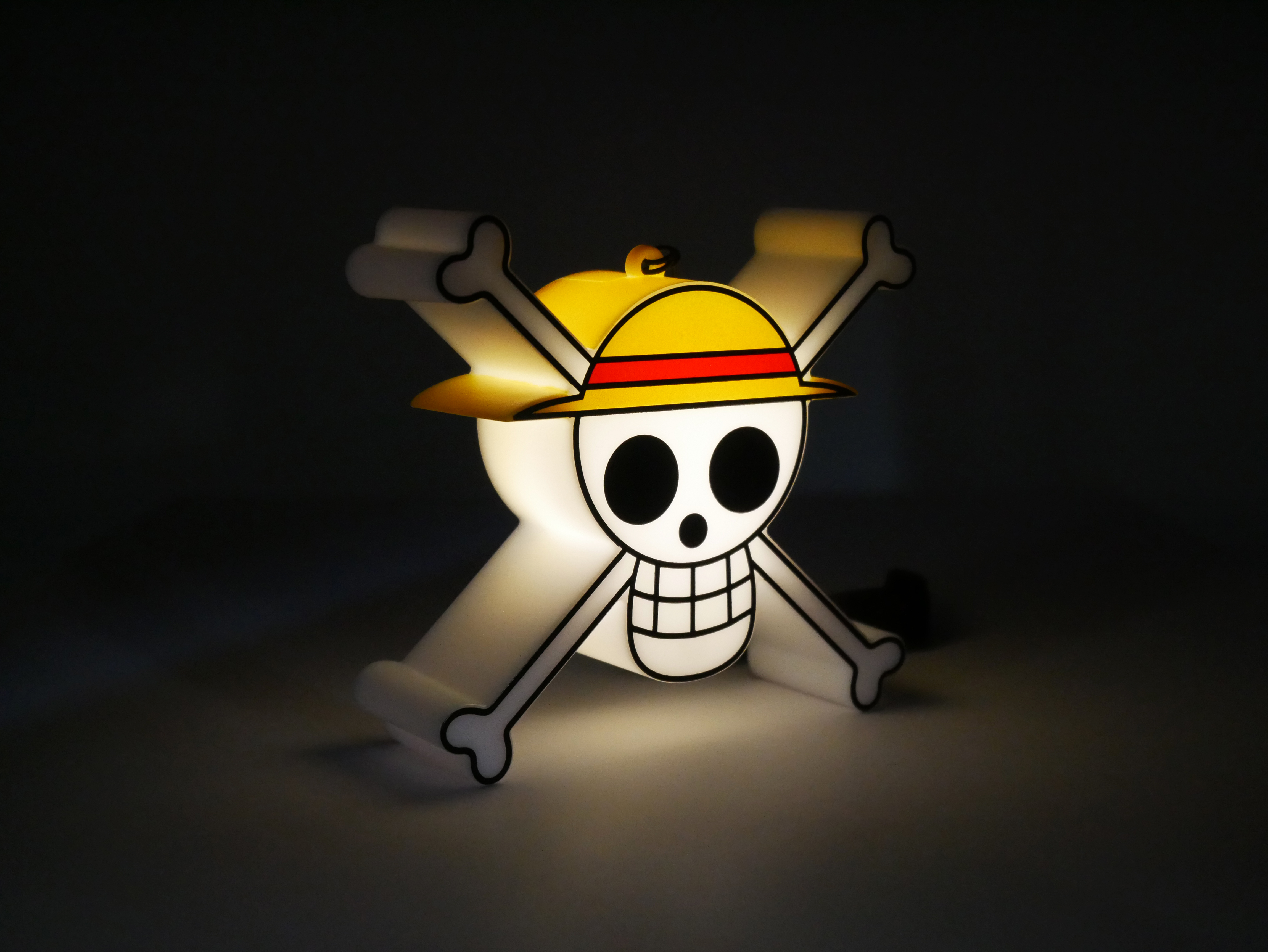 Ein leuchtendes Totenkopfsymbol mit gelbem Hut und gekreuzten Knochen.