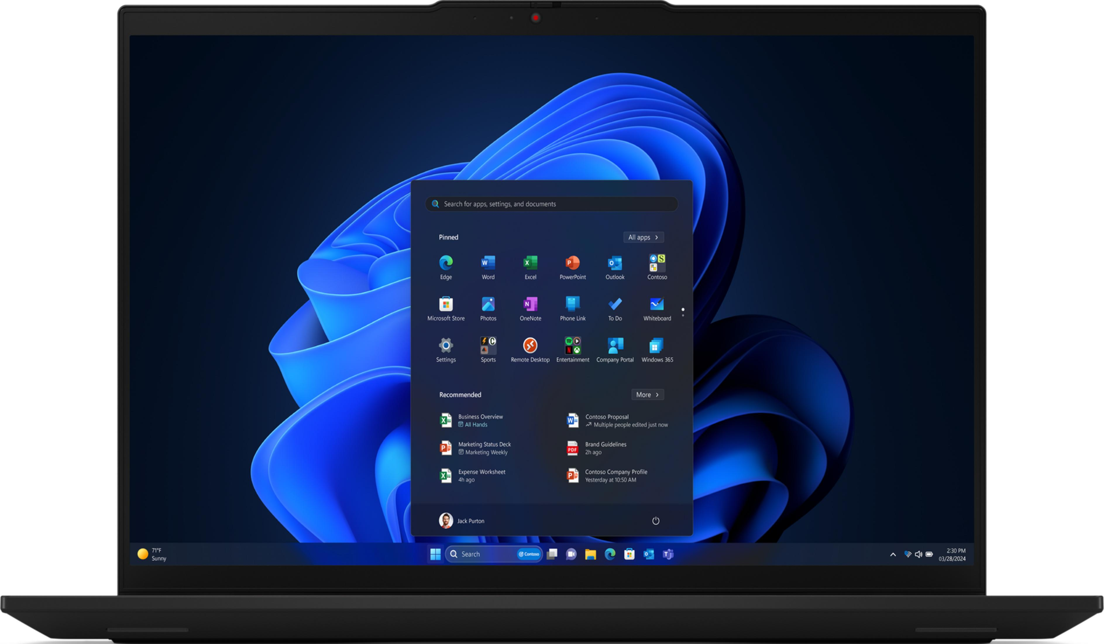 Un laptop aperto mostra il menu Start di Windows 11 con sfondo blu ondulato.