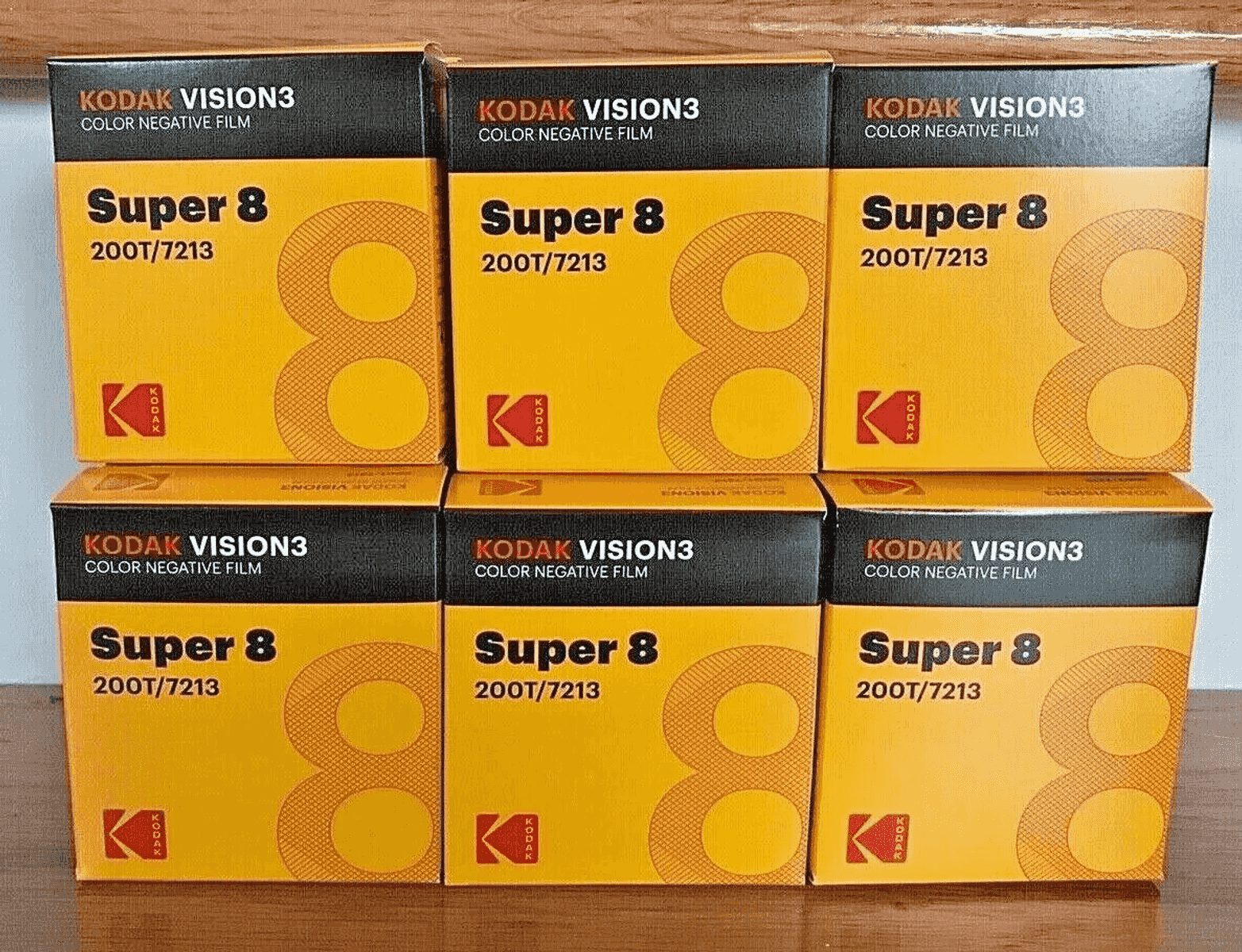 Seis paquetes de película Kodak Vision3 Super 8 sobre una superficie de madera.