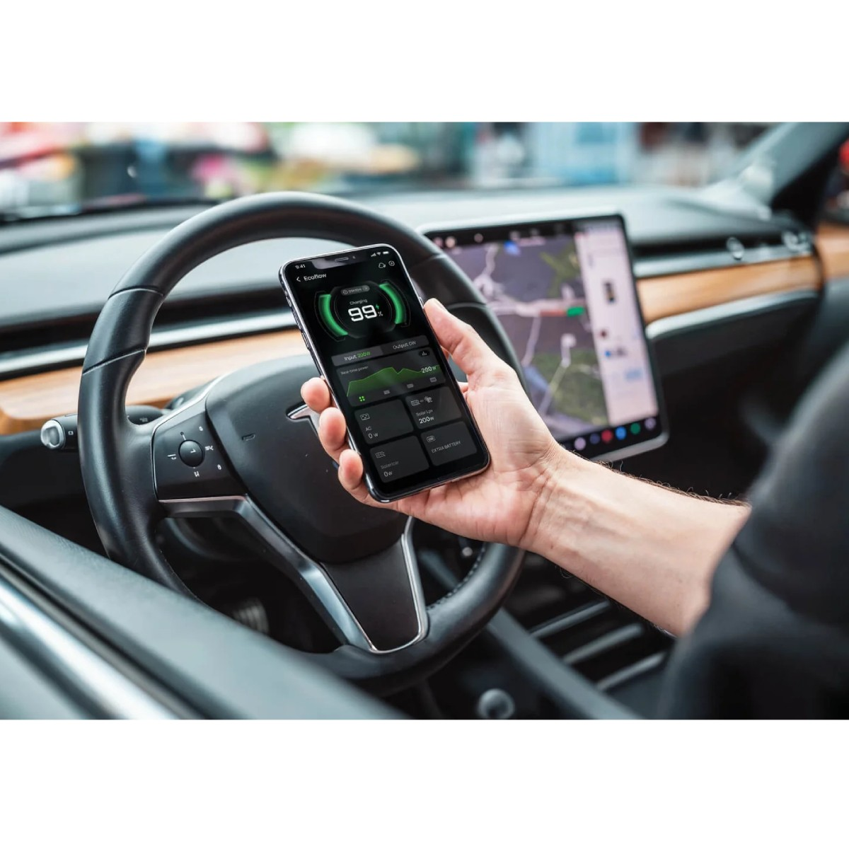 Mano sosteniendo smartphone con app Ecoflow en coche, mostrando 99% carga.