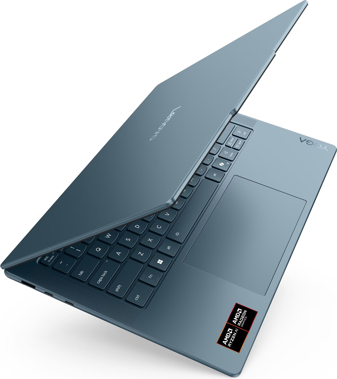 Mavi bir Lenovo Yoga dizüstü bilgisayar açık, klavye ve dokunmatik yüzeyi görünüyor. AMD Ryzen AI ve Radeon grafik çıkartmaları görünür.