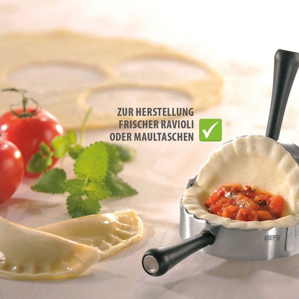 Machine à raviolis avec pâte, tomates, menthe et garniture.