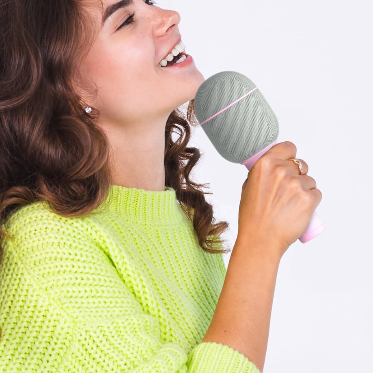 Giovane donna in maglione verde neon che tiene un microfono.