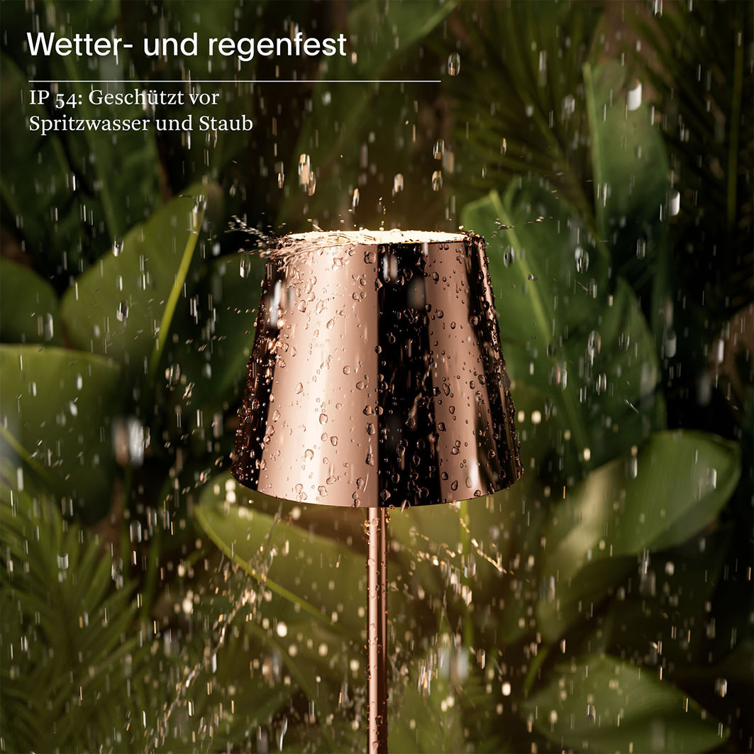 Eine Kupferlampe im Regen, mit Wassertropfen auf der Oberfläche und üppigem grünen Laub im Hintergrund.