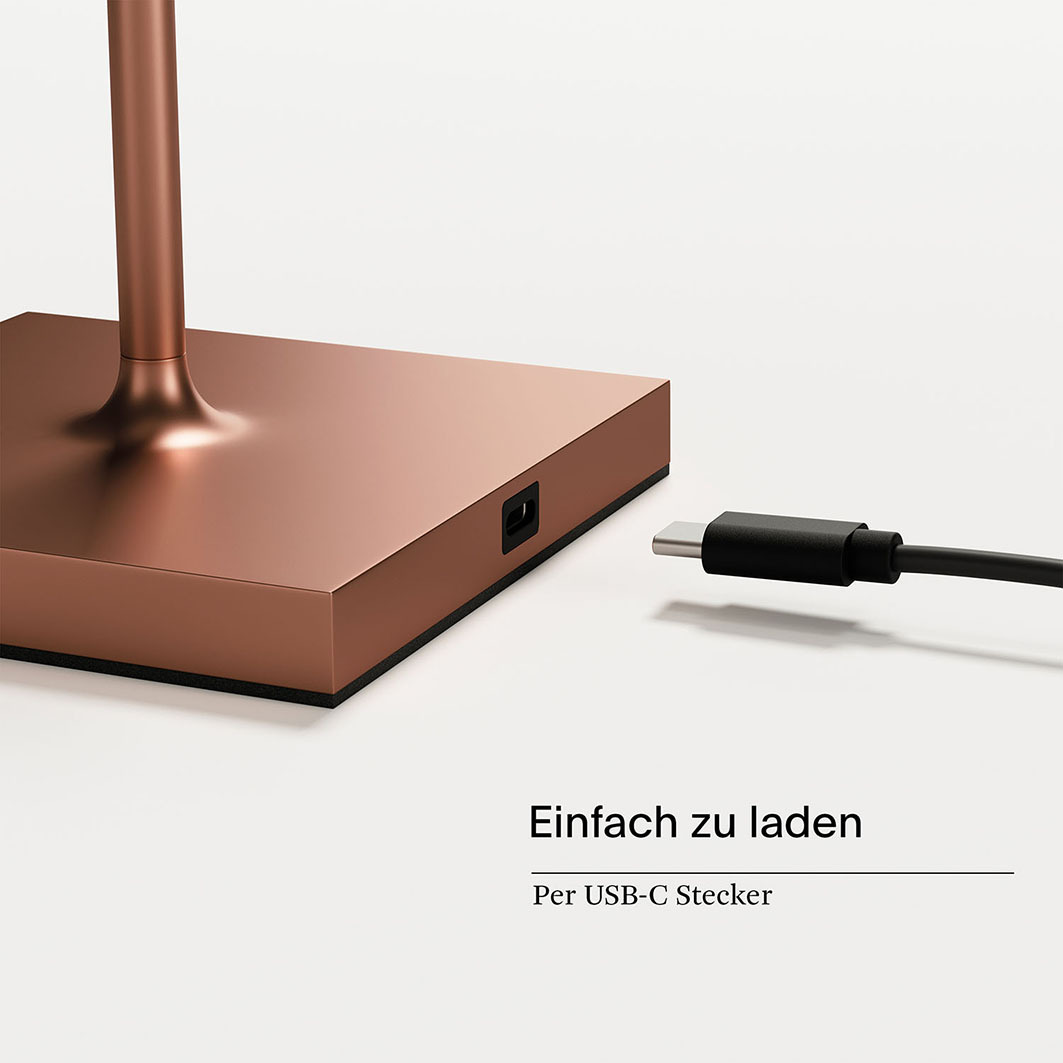 Eine kupferfarbene Lampe mit einem USB-C-Anschluss und einem Kabel.