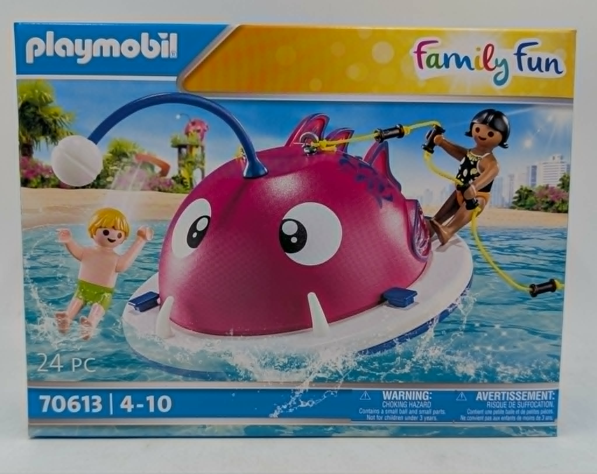 Pudełko Playmobil z różową łodzią rybą, dwójką dzieci w wodzie i pluskami.