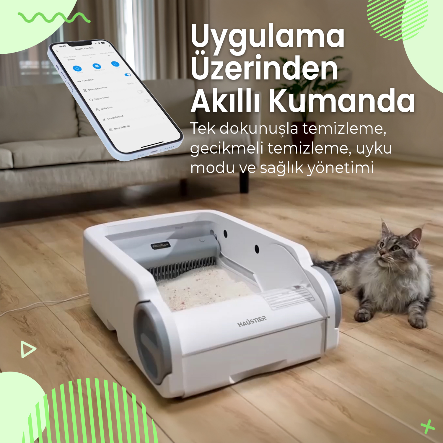 Gri bir kedi beyaz otomatik bir kedi kumunun yanında yatıyor. Telefon ekranında uygulama kontrolleri görünüyor.