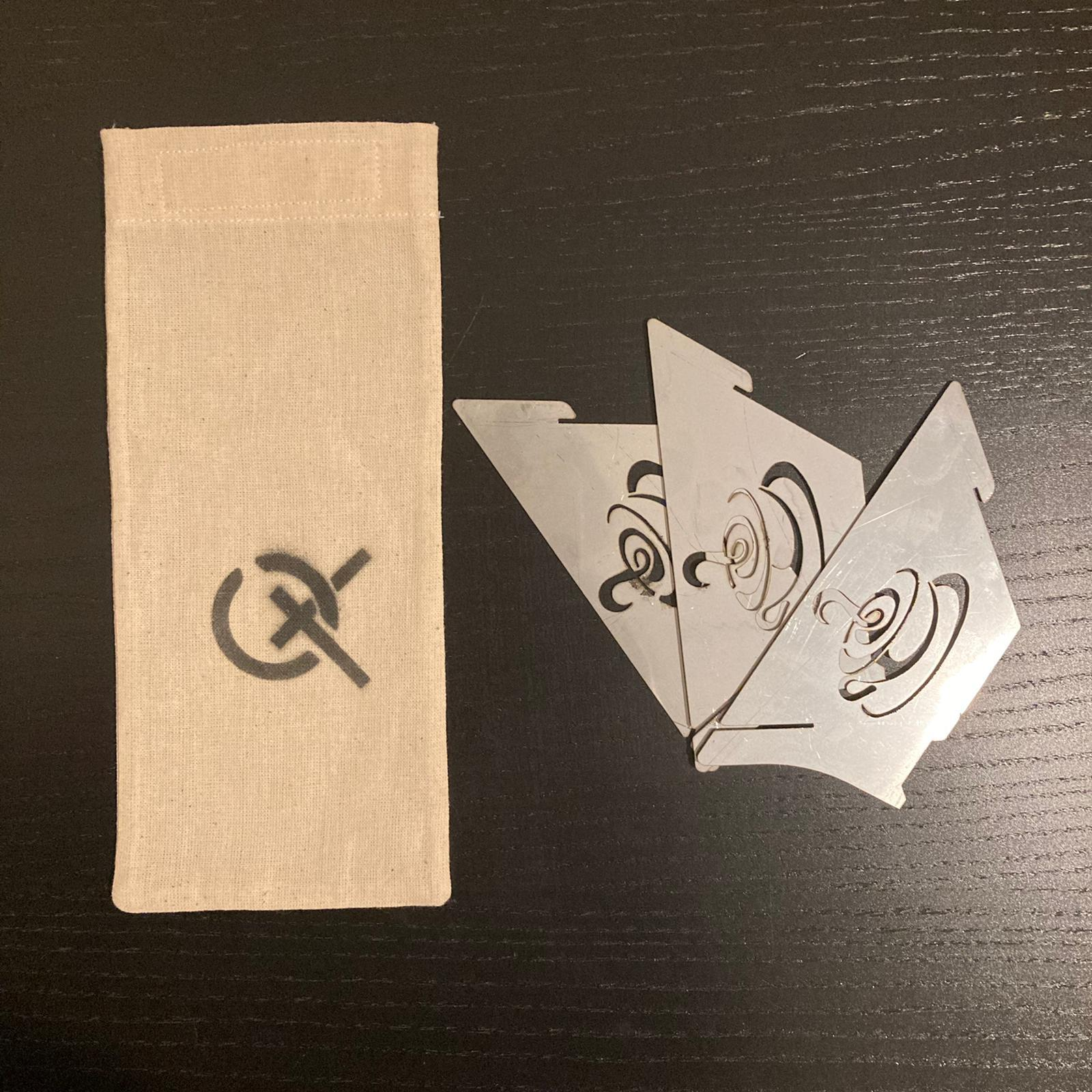 Kahve fincanı desenli üç gümüş metal altlığın yanında bir logo bulunan bez çanta.