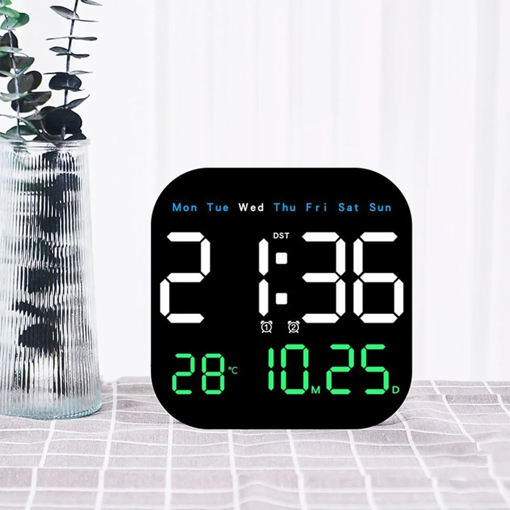 Digitaluhr zeigt 2:36, 28°C und 10.25. daneben eine Vase mit Zweigen.