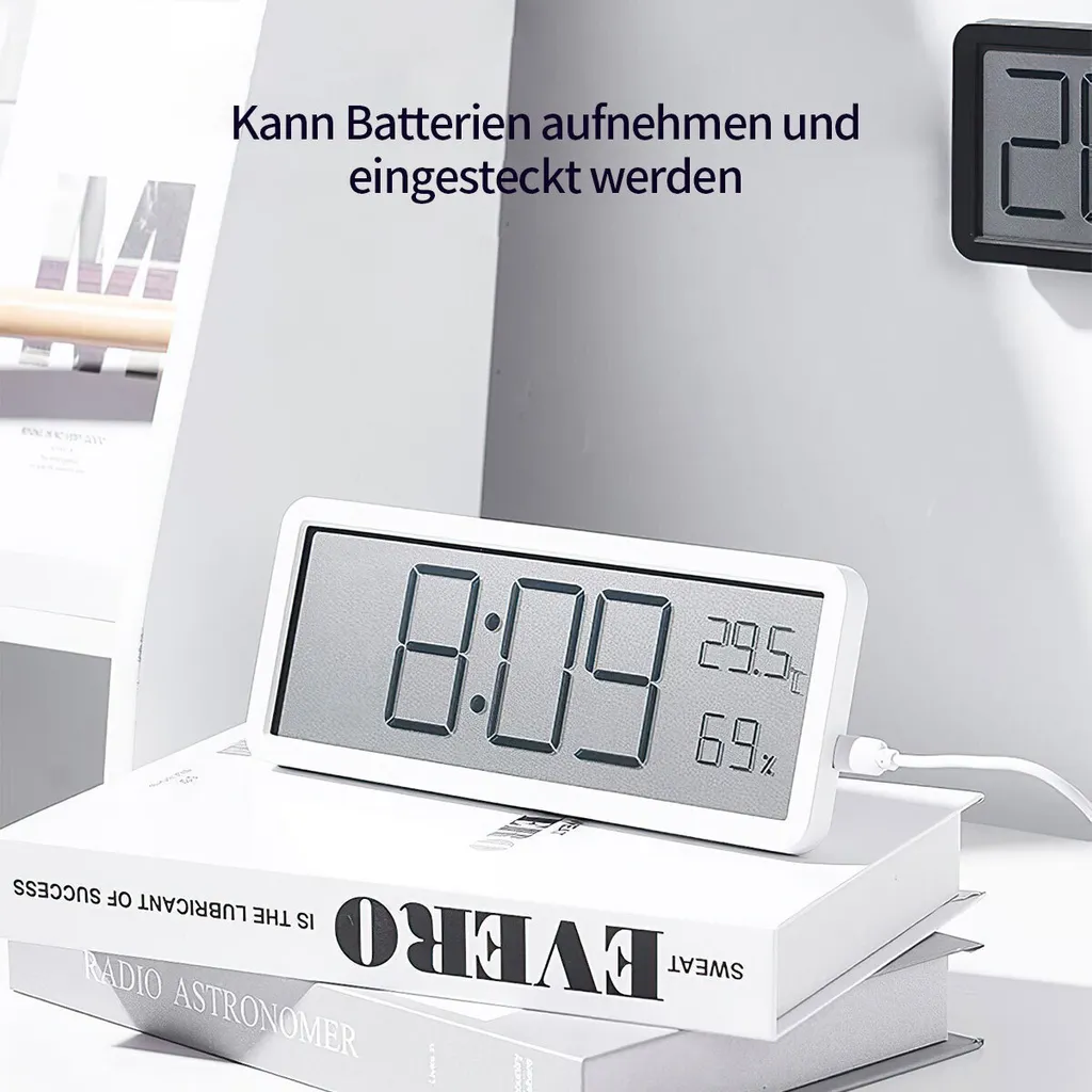 Ein weißer digitaler Wecker zeigt 8:09 und Raumtemperatur/Luftfeuchtigkeit an.