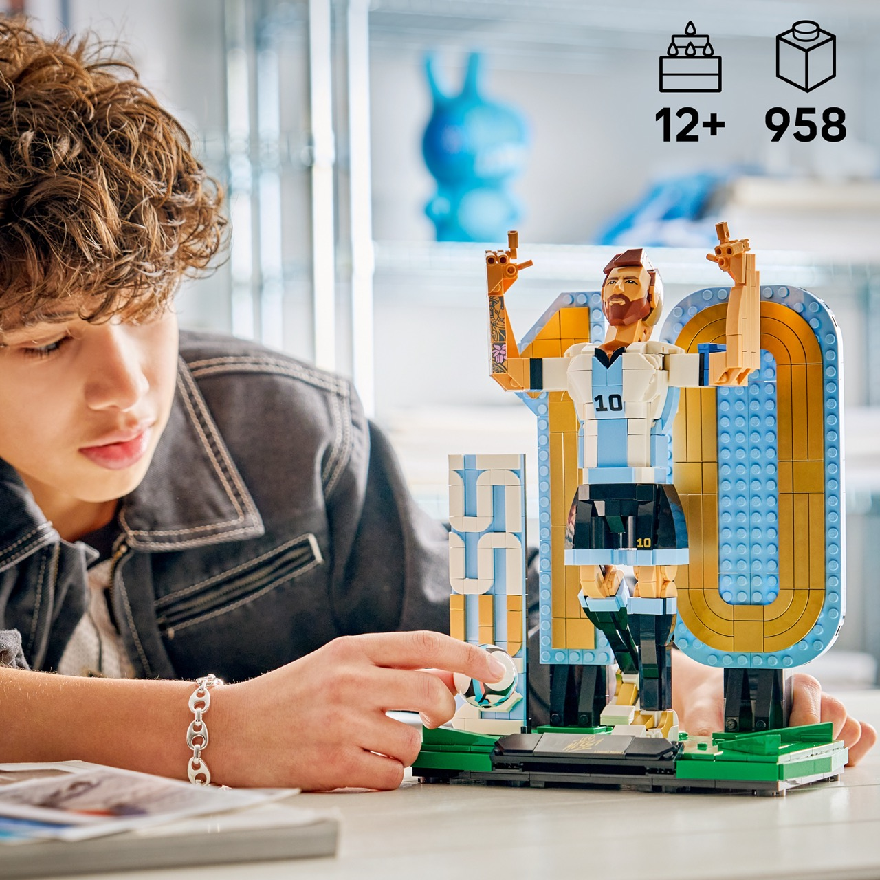 Un ragazzo costruisce un calciatore Lego con maglia Argentina, 12+, 958 pezzi.