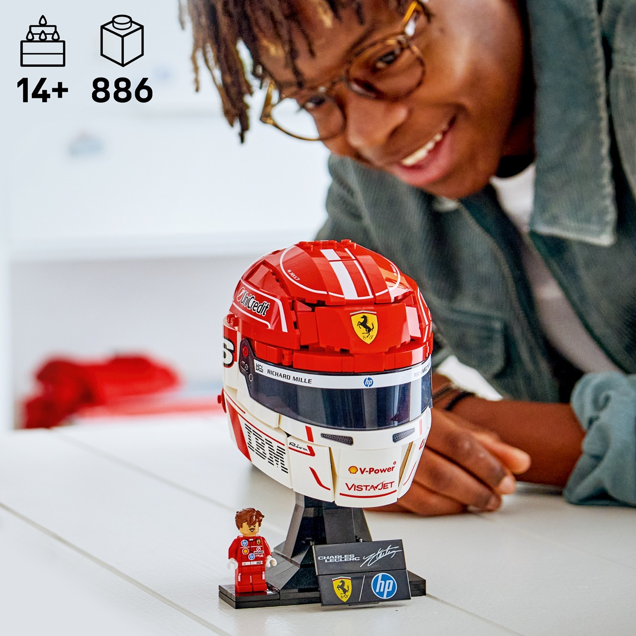 Osoba patrzy na czerweno-biały kask LEGO Ferrari z minifigurką.
