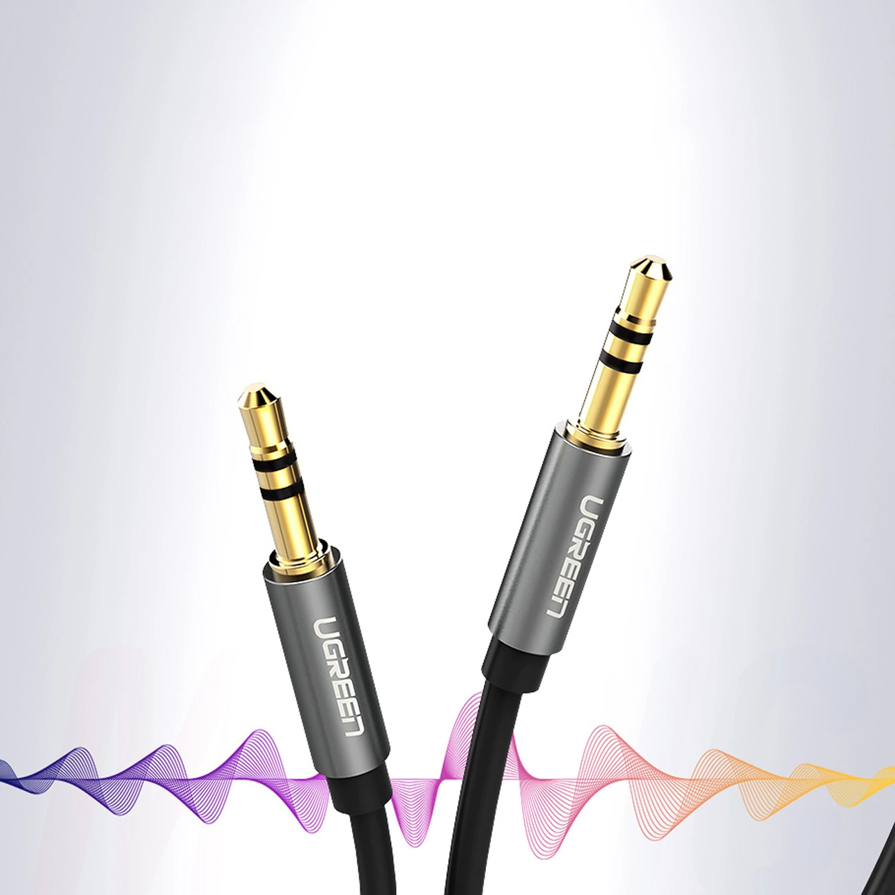 Zwei goldene 3,5-mm-Audiostecker mit silbernen UGREEN-Griffen und Wellenlinien.