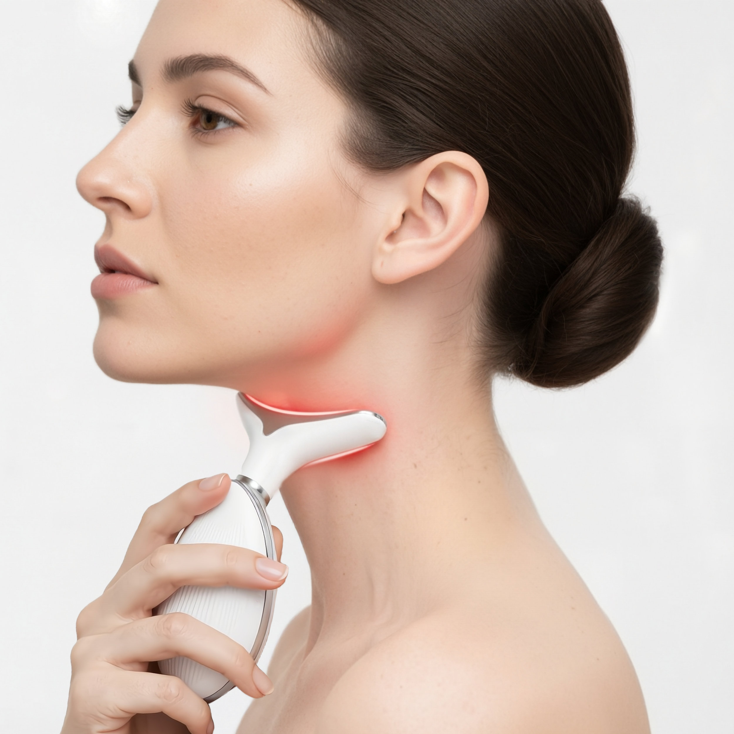 Mujer de perfil usando un dispositivo de cuidado de la piel blanco con luz roja en el cuello.
