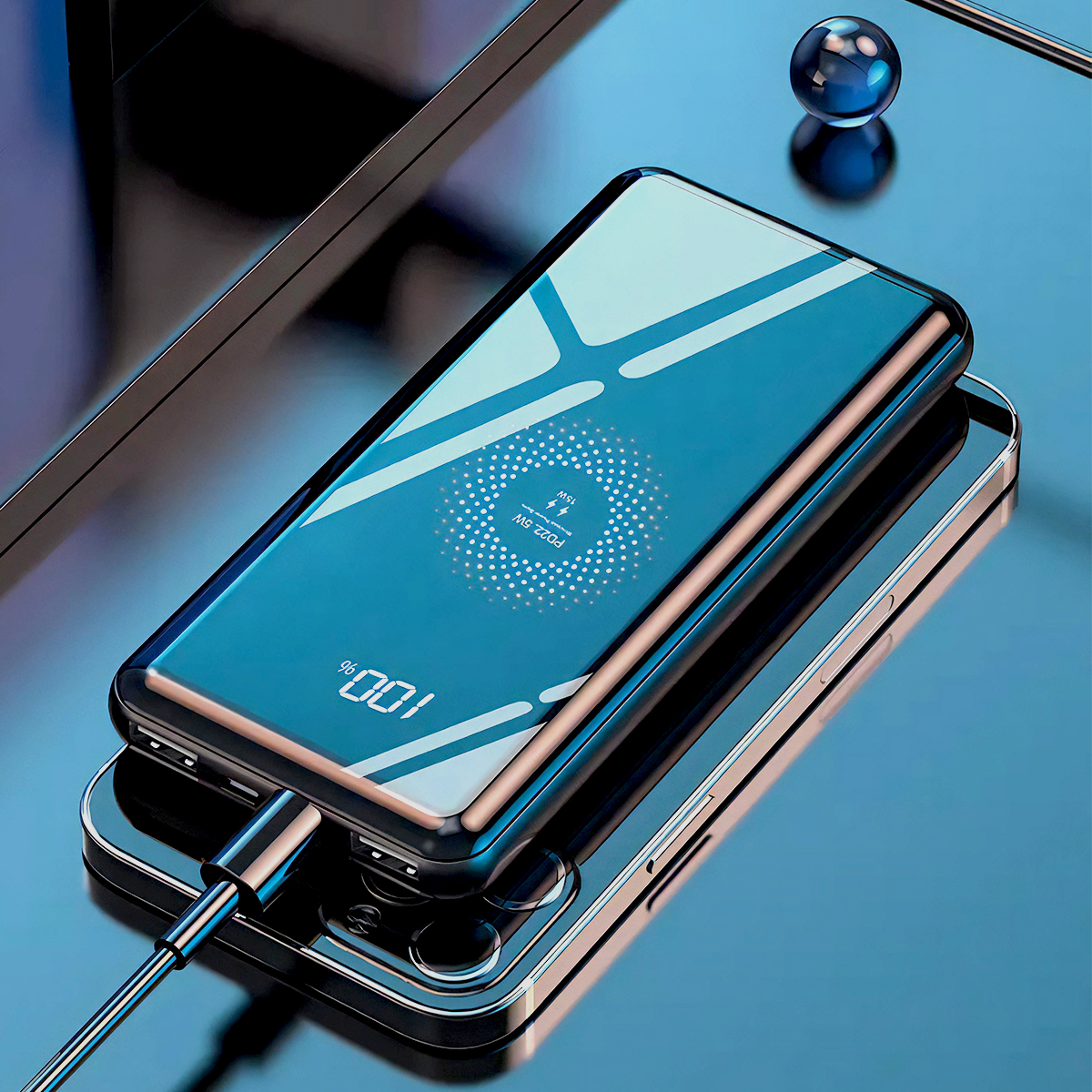Parlak mavi bir powerbank akıllı telefonun üzerinde duruyor. Kablo bağlı.