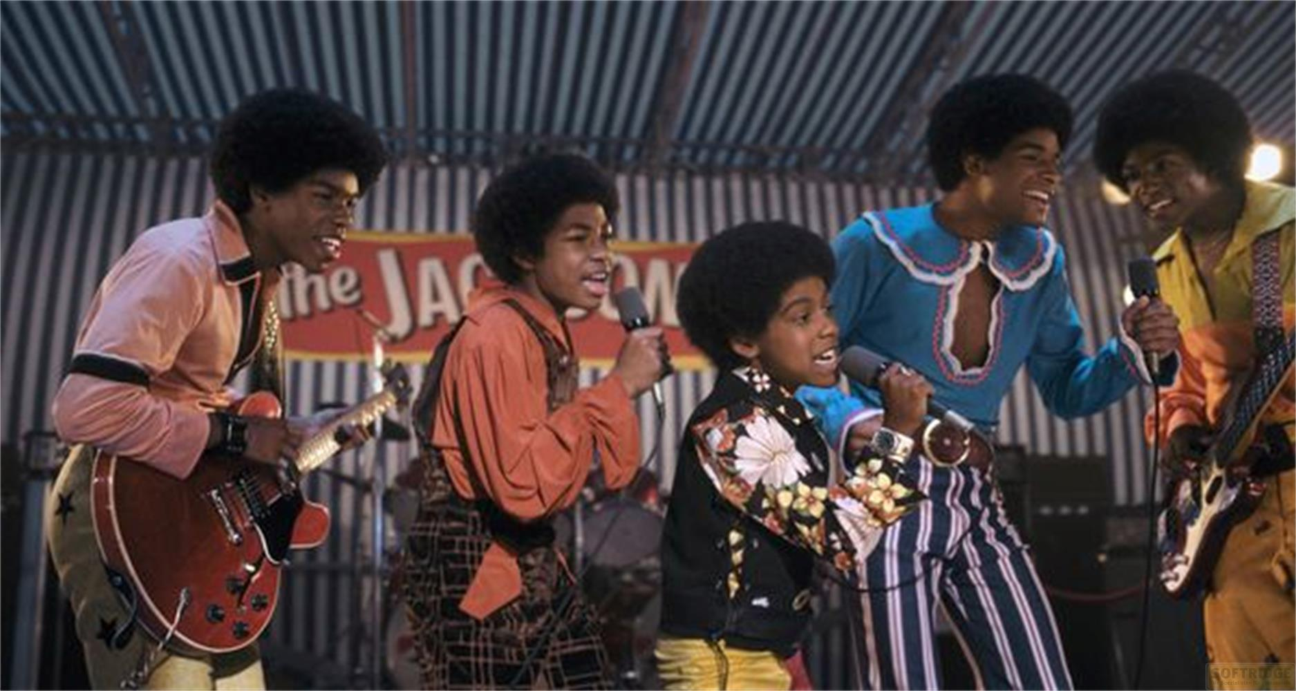 Fünf Jungen der Jackson 5 singen und spielen auf einer Bühne mit einem Banner.