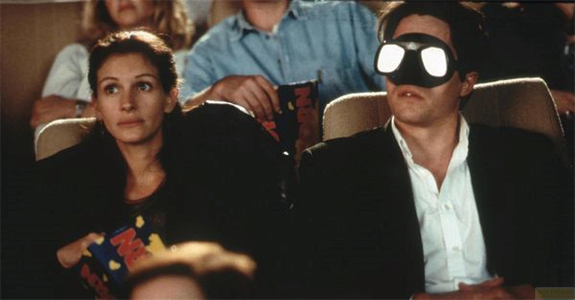 Donna con popcorn e uomo con occhiali 3D al cinema.