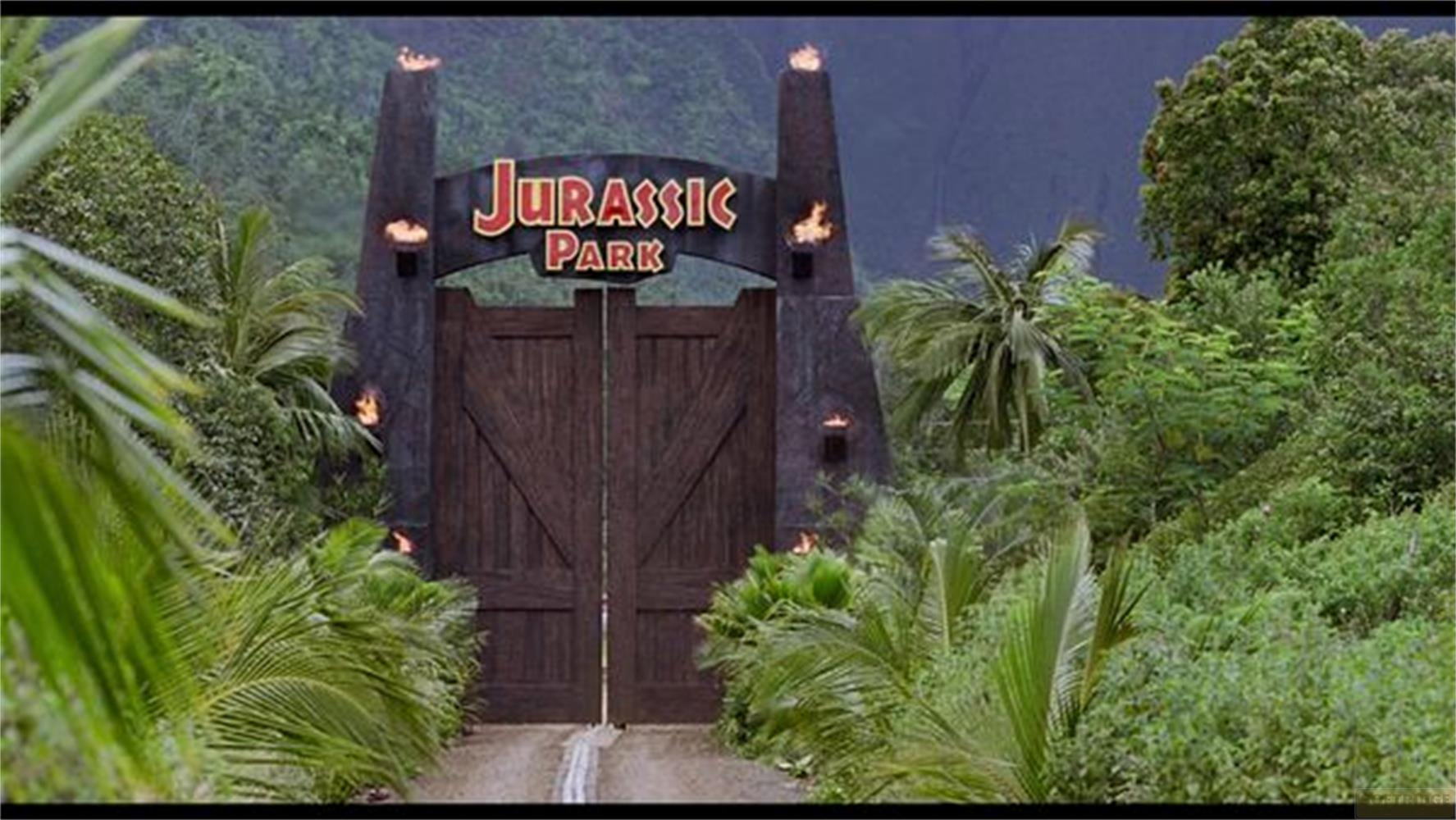 Cancello d'ingresso di Jurassic Park con fiamme e fogliame lussureggiante.