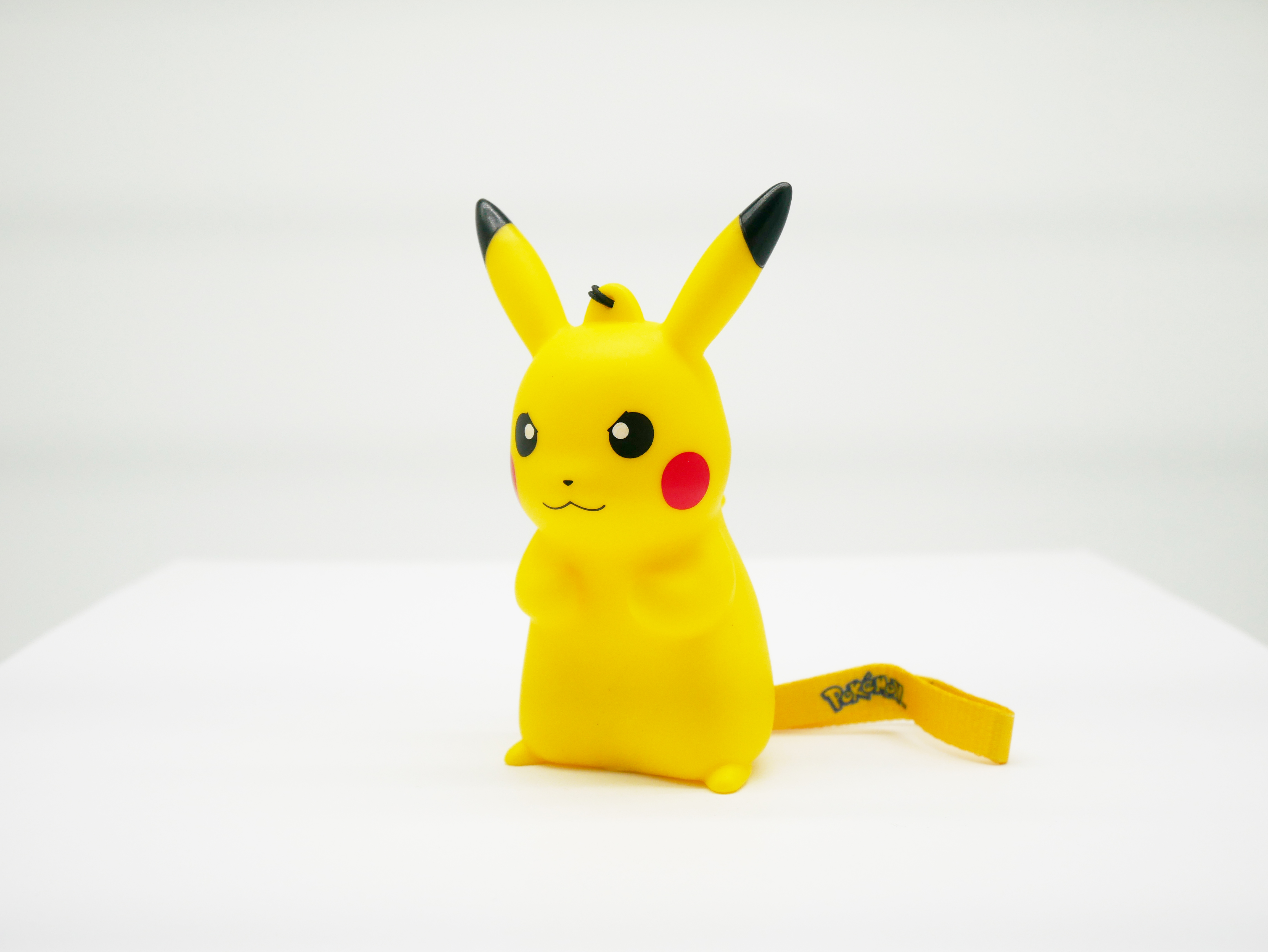 Eine gelbe Pikachu-Figur mit schwarzspitzen Ohren und roten Wangen auf weißem Untergrund.