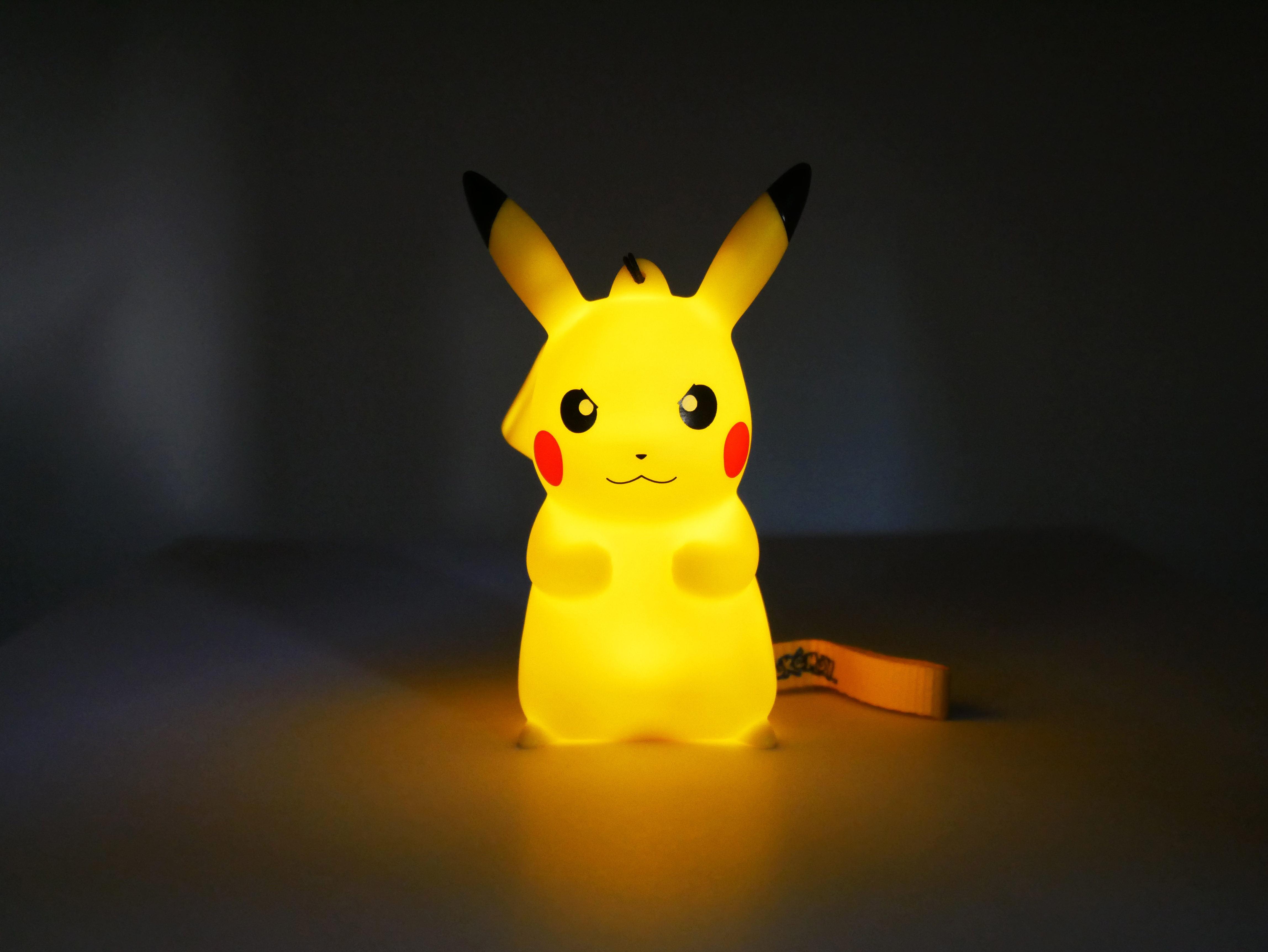 Leuchtende gelbe Pikachu-Figur mit schwarzen Ohrenspitzen und roten Wangen.